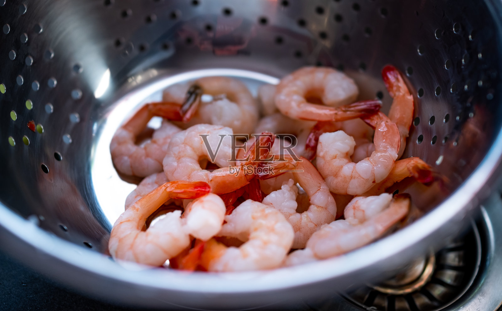 用漏勺给大虾解冻照片摄影图片