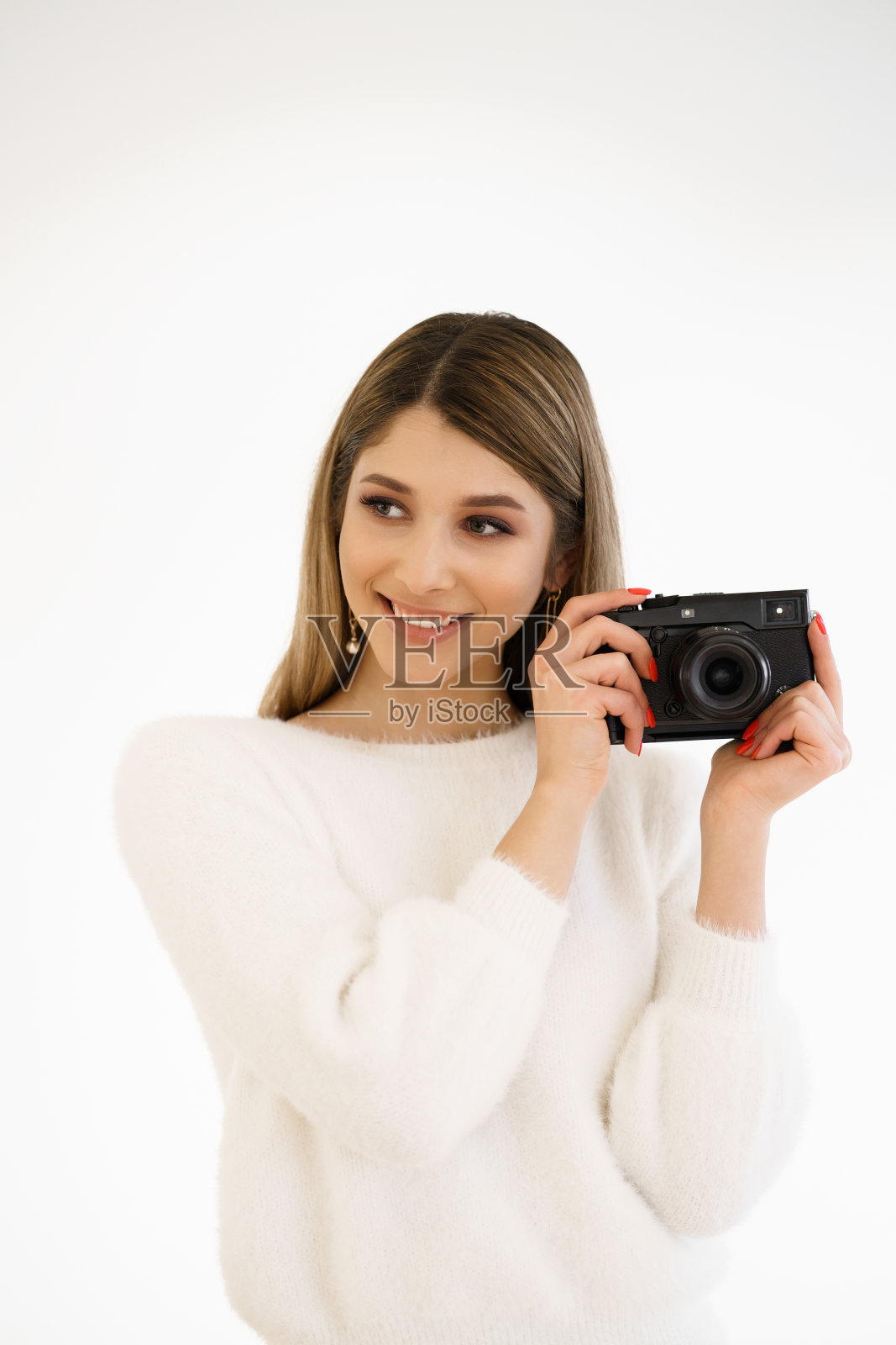 微笑的女人拿着相机在白色的背景照片摄影图片