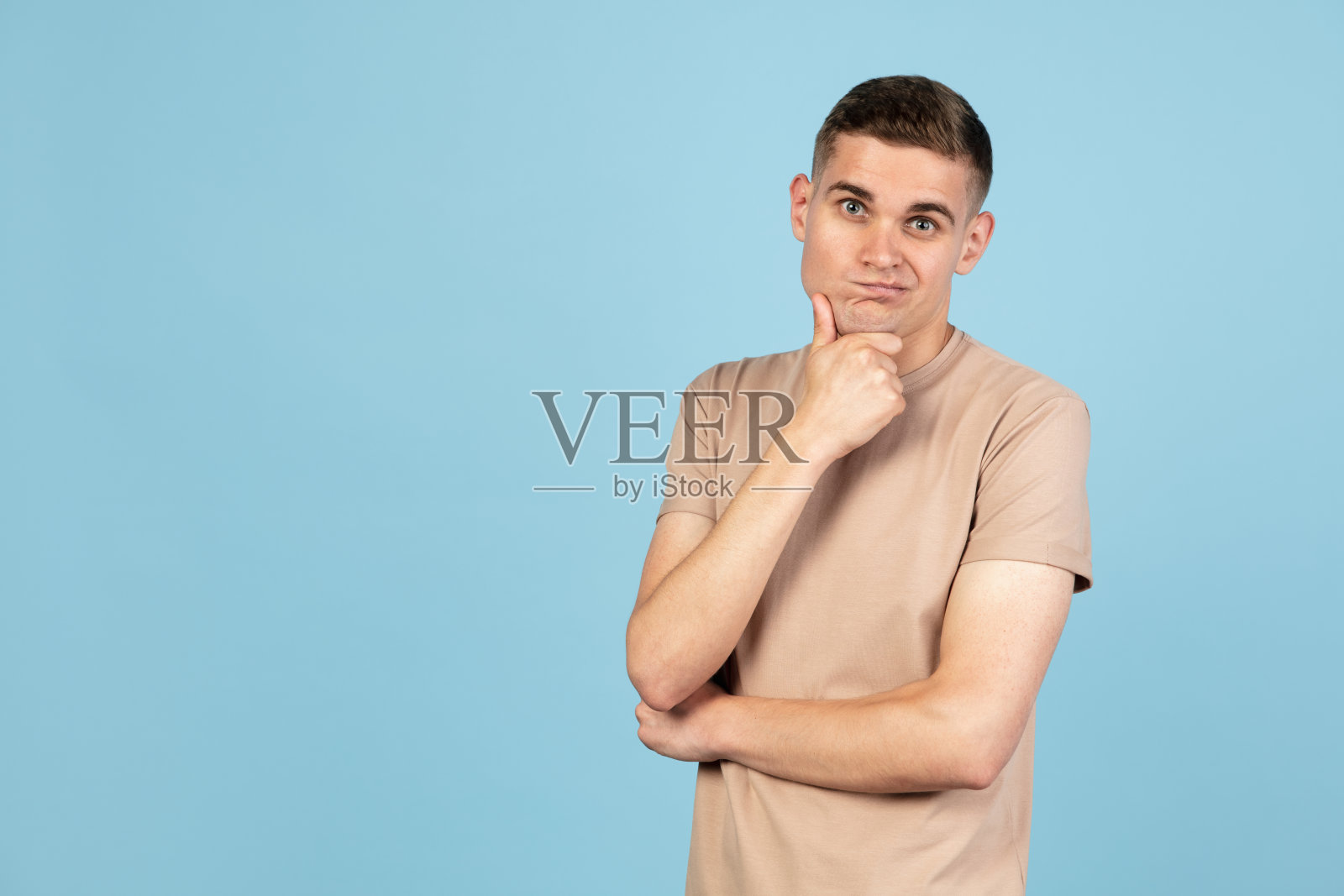 年轻白人男子的肖像孤立在蓝色工作室背景与广告copyspace。人类情感的概念照片摄影图片