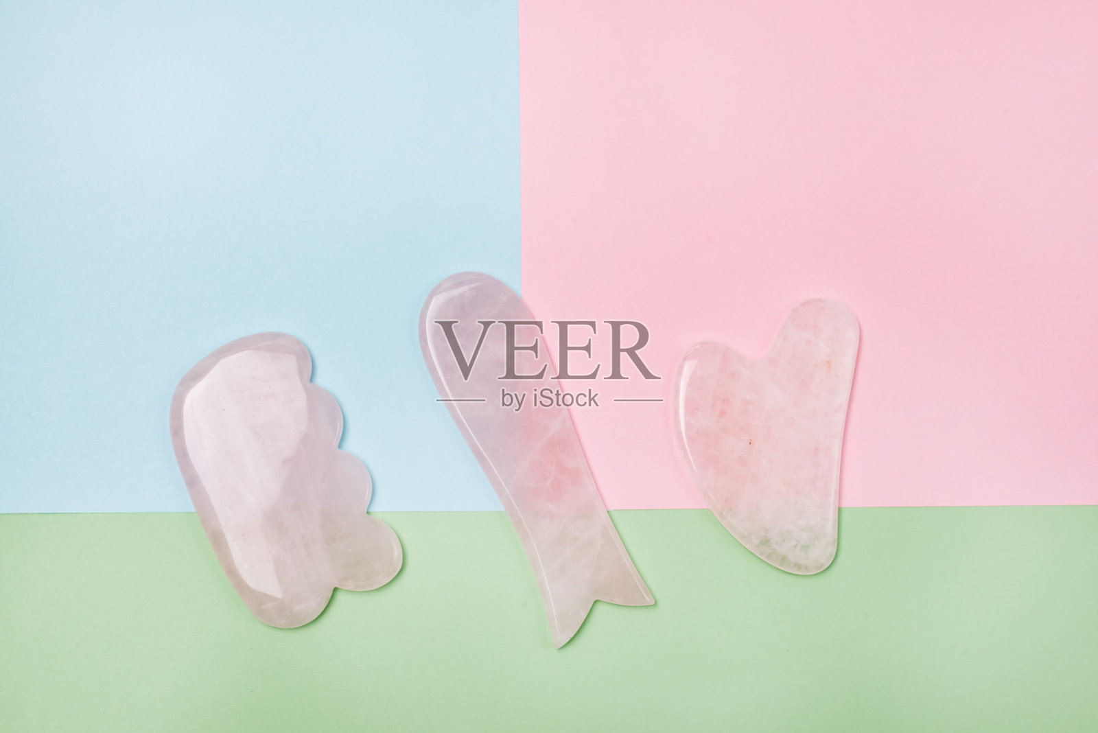 美容按摩粉玉刮沙刮刀面部和身体皮肤护理Spa和美容概念黄蓝色和粉色块背景最小照片摄影图片