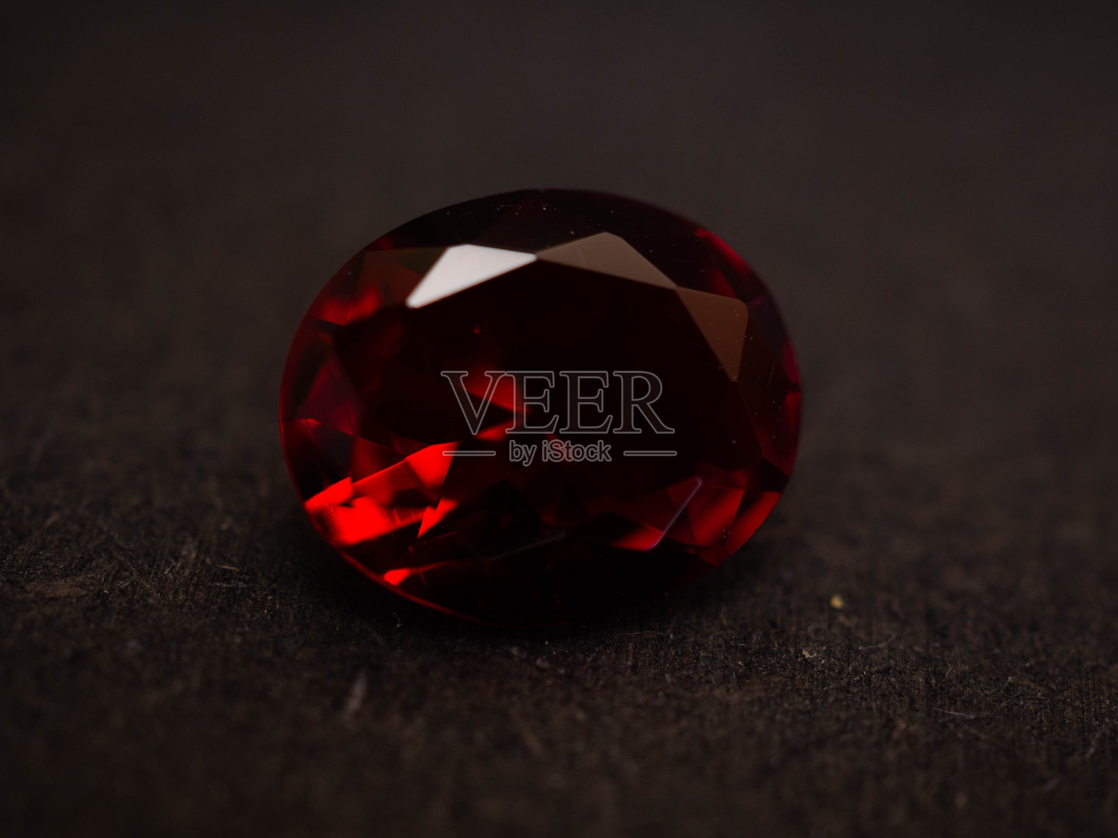 近距离拍摄在上雕琢平面的红色钻石般的宝石照片摄影图片