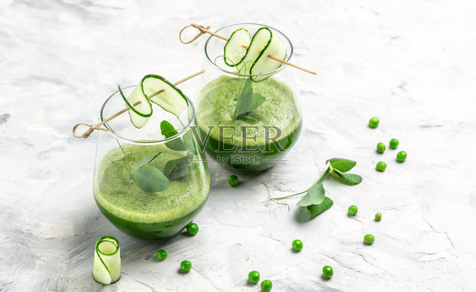 一杯新鲜的绿色冰沙，有机蔬菜和酸橙，排毒冰沙，新鲜绿豌豆，黄瓜，菠菜和酸橙。健康排毒饮料照片摄影图片