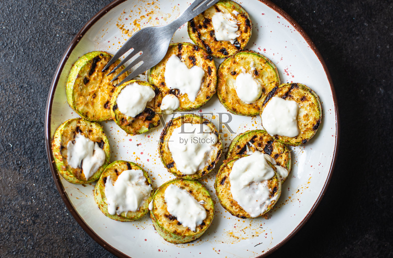 餐桌上有烤西葫芦炒蔬菜，健康小吃仿太空美食背景质朴。顶视图生酮或旧石器饮食素食或素食食品照片摄影图片