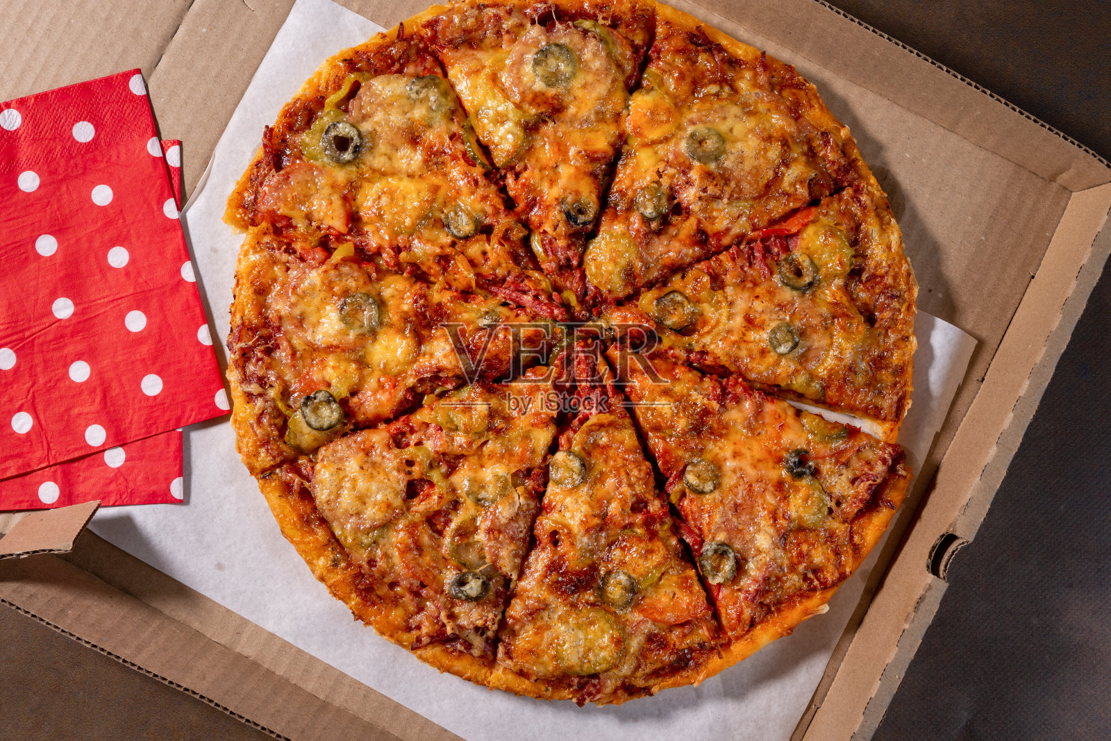 黑色背景下的外卖盒里的披萨。在网上订一份晚餐。舒适的乘坐。照片摄影图片