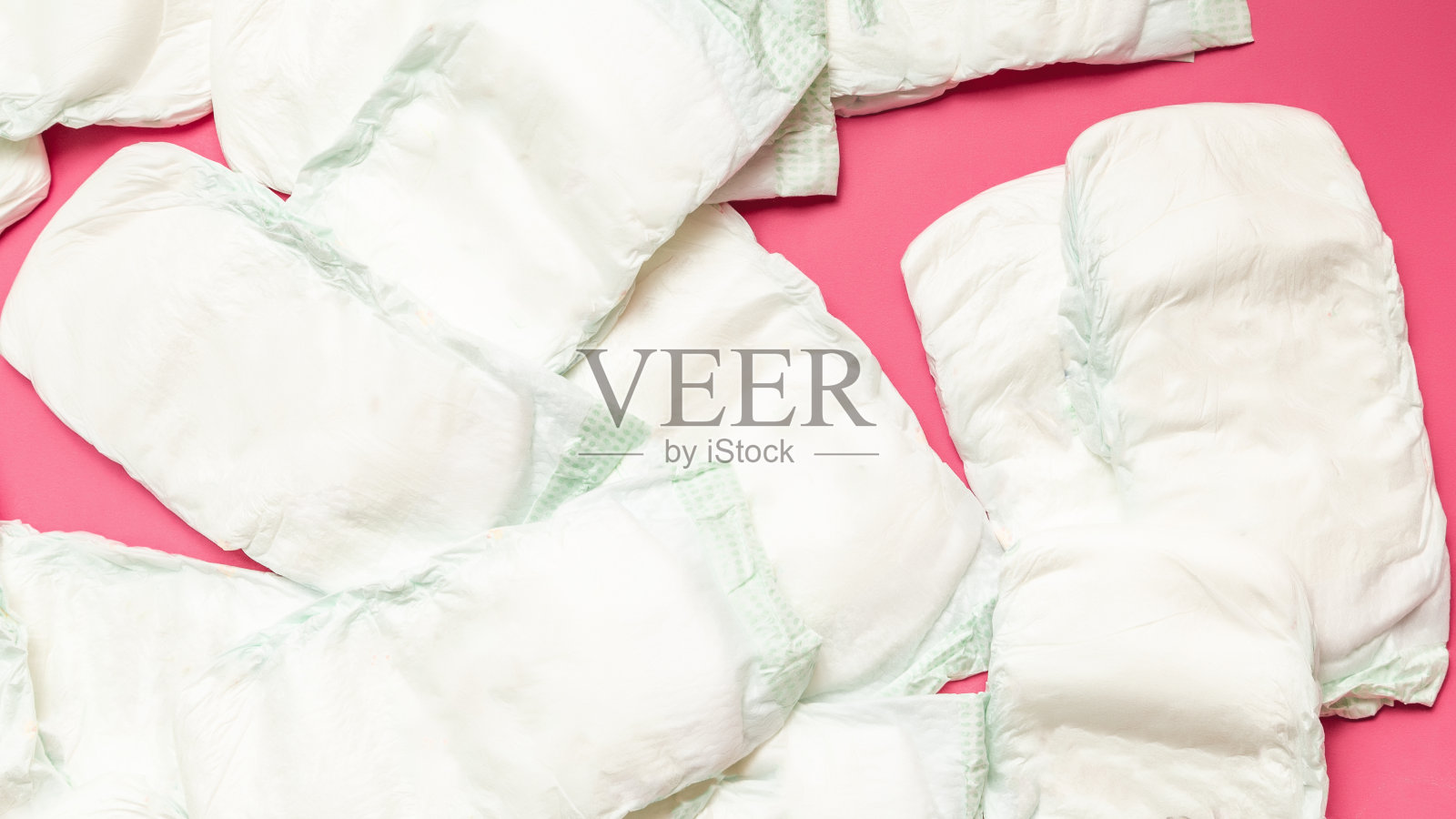 新生儿护理配件。粉色背景的儿童尿布。前视图。卫生的新生儿照片摄影图片