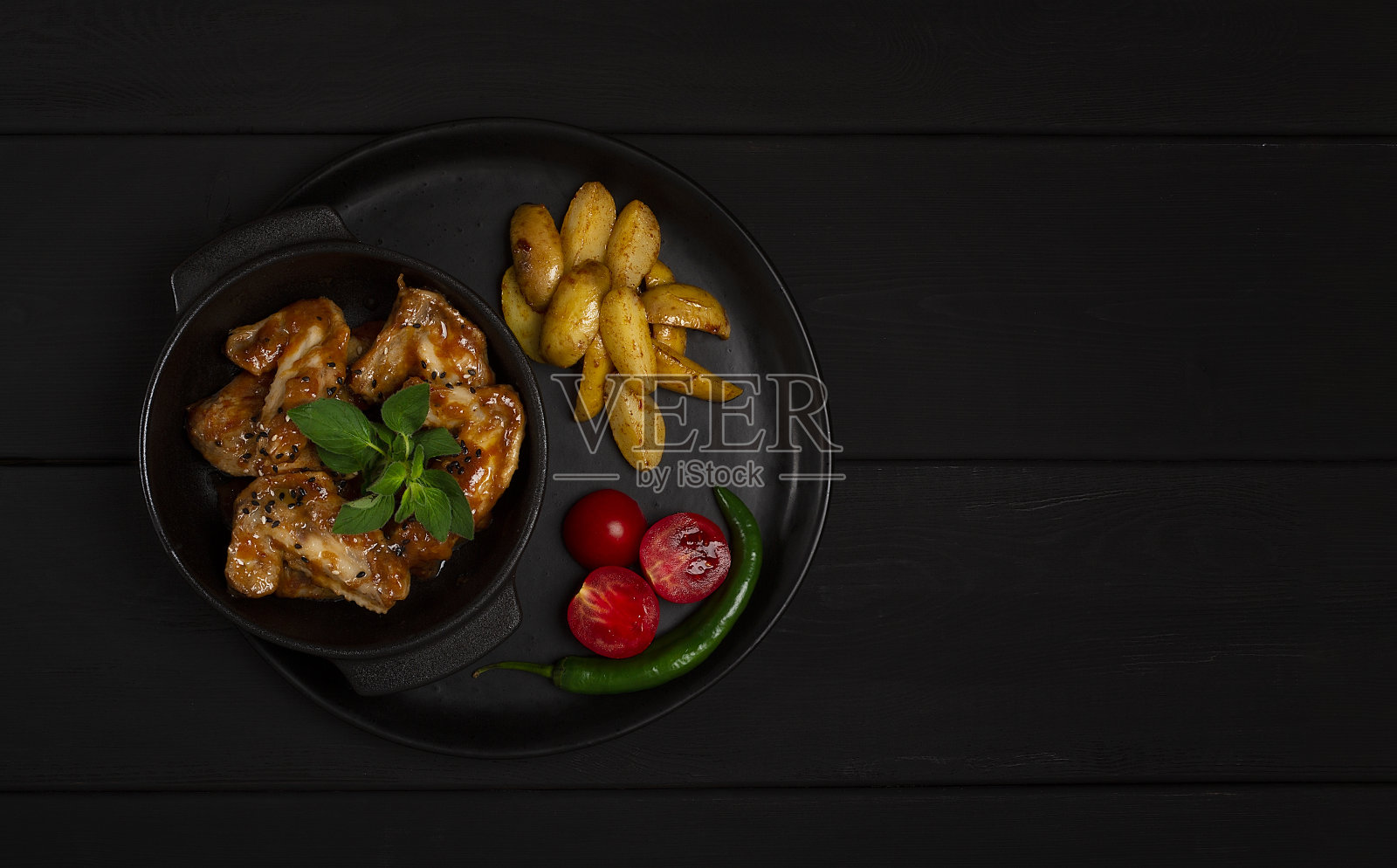 鸡翅，油炸，烧烤，土豆，在一个黑色的盘子上，俯视图，没有人，水平照片摄影图片