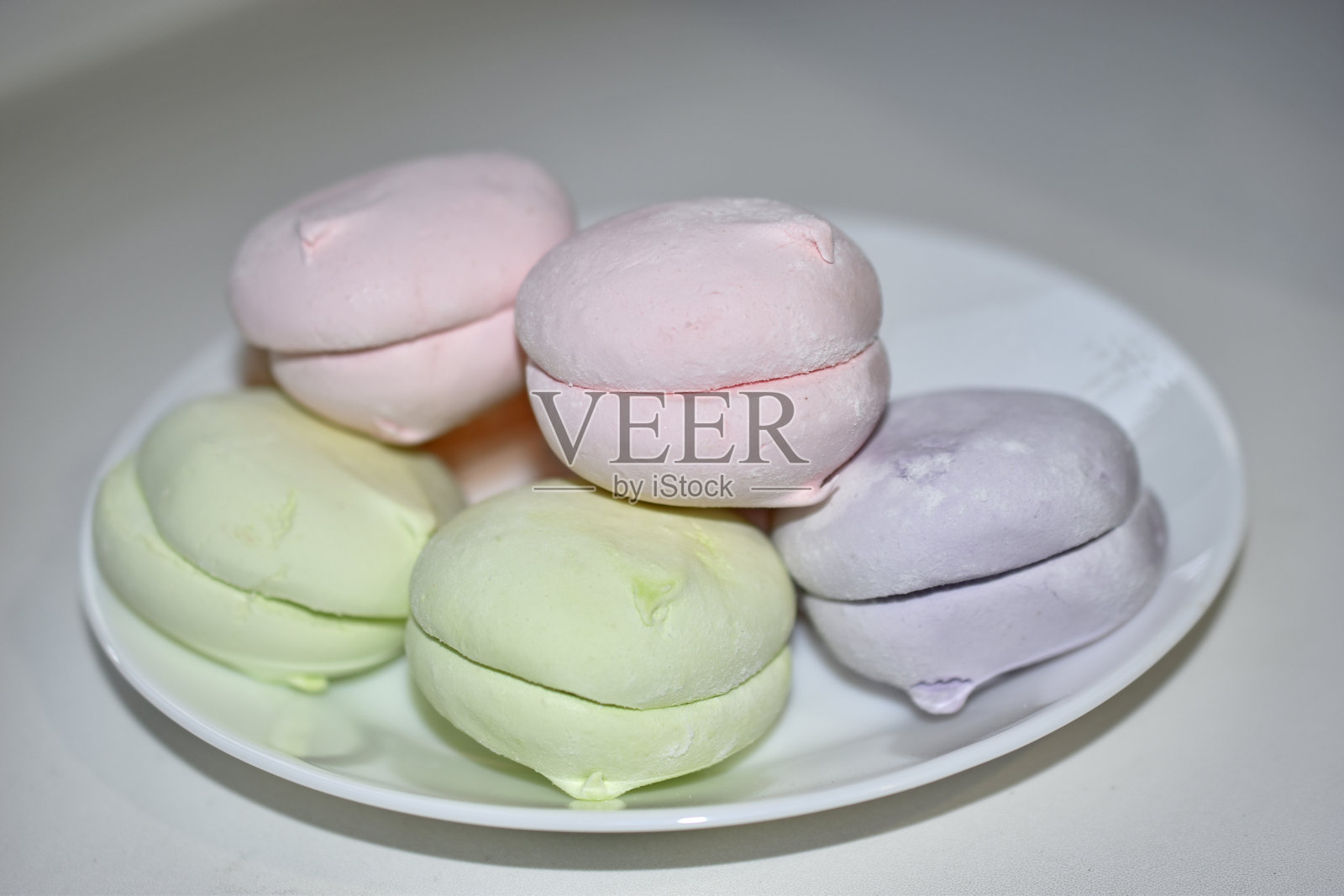 白色盘子上放着五颜六色的美味棉花糖照片摄影图片