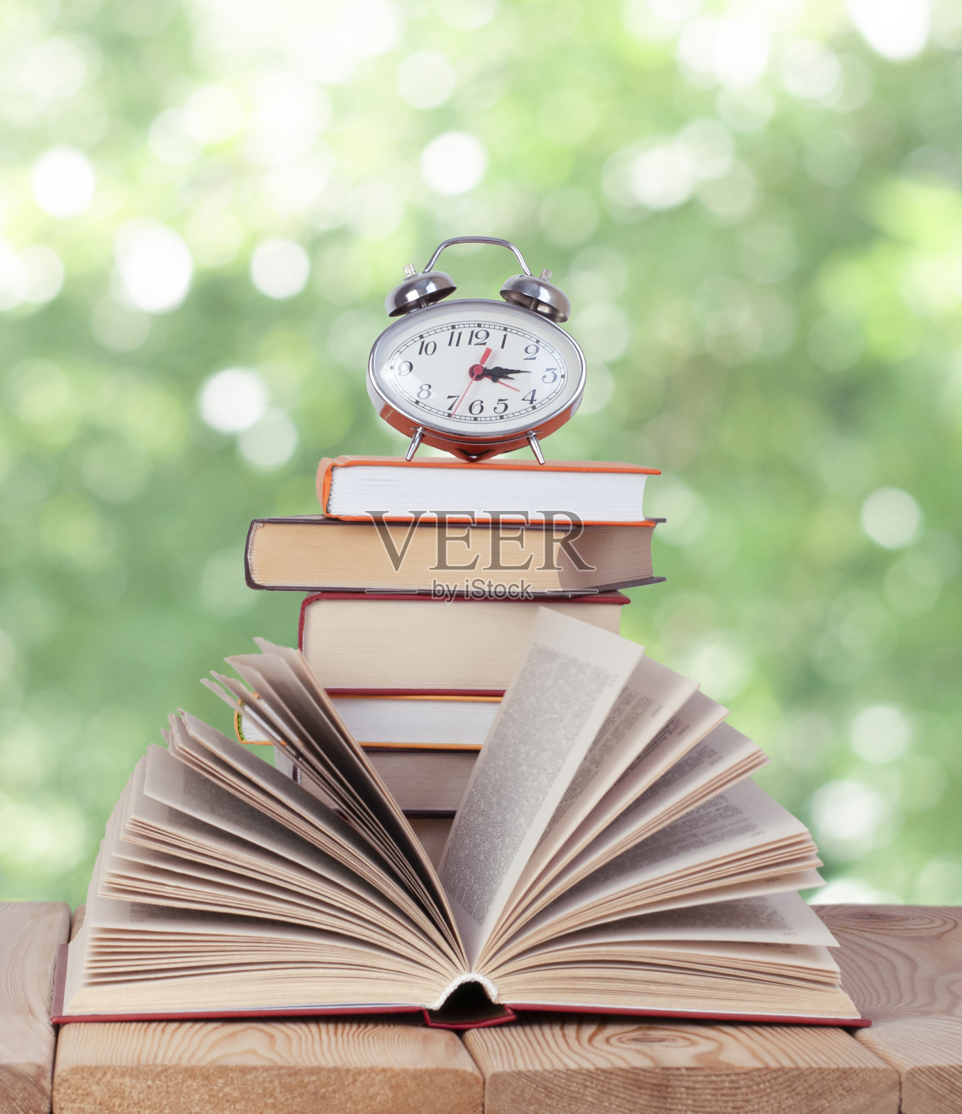 翻开书用银表就可以在自然的书堆上照片摄影图片