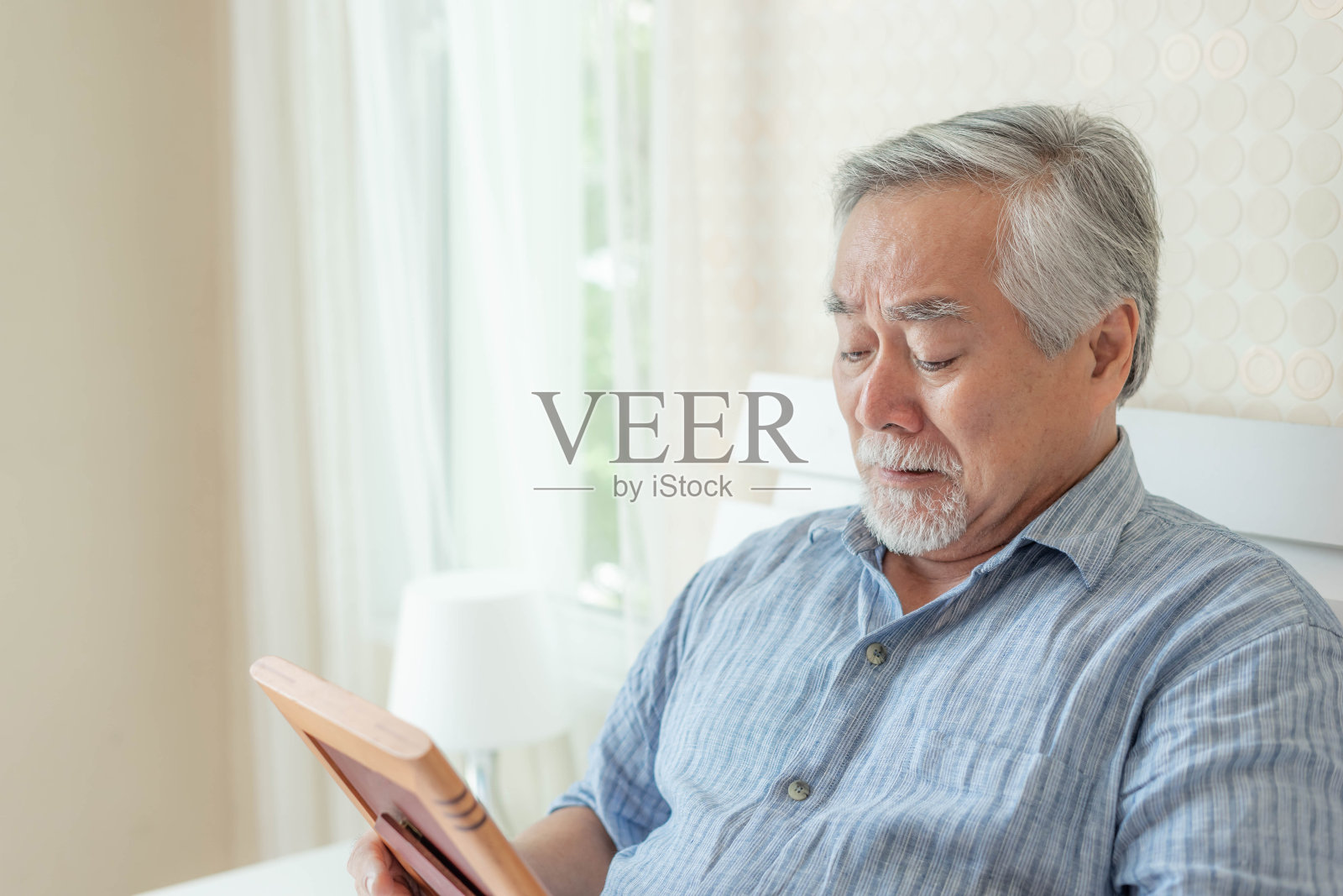 老爷子不高兴的是哭着，抱着亡妻的形象，想起自己的妻子情夫——老爷子伤心地概念照片摄影图片