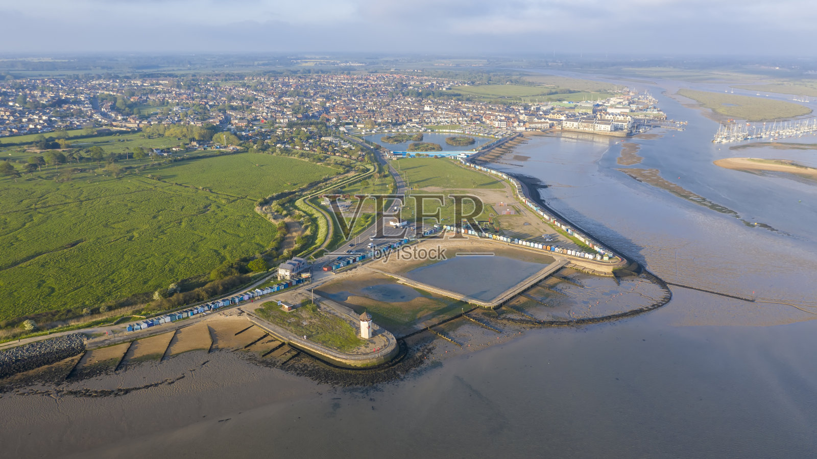 英国埃塞克斯，明亮的海灯塔塔在日落与惊人的光特别的海边日照片摄影图片