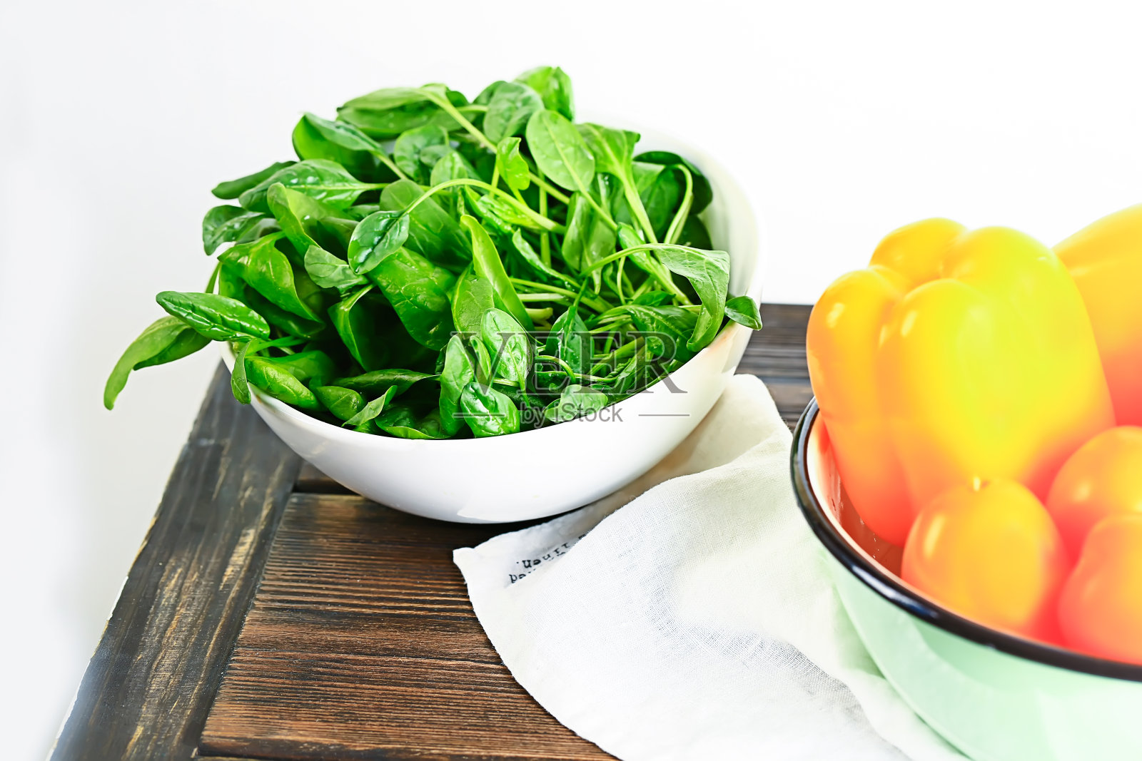 夏季蔬菜沙拉的配料。木桌上放着新鲜菠菜和青椒照片摄影图片