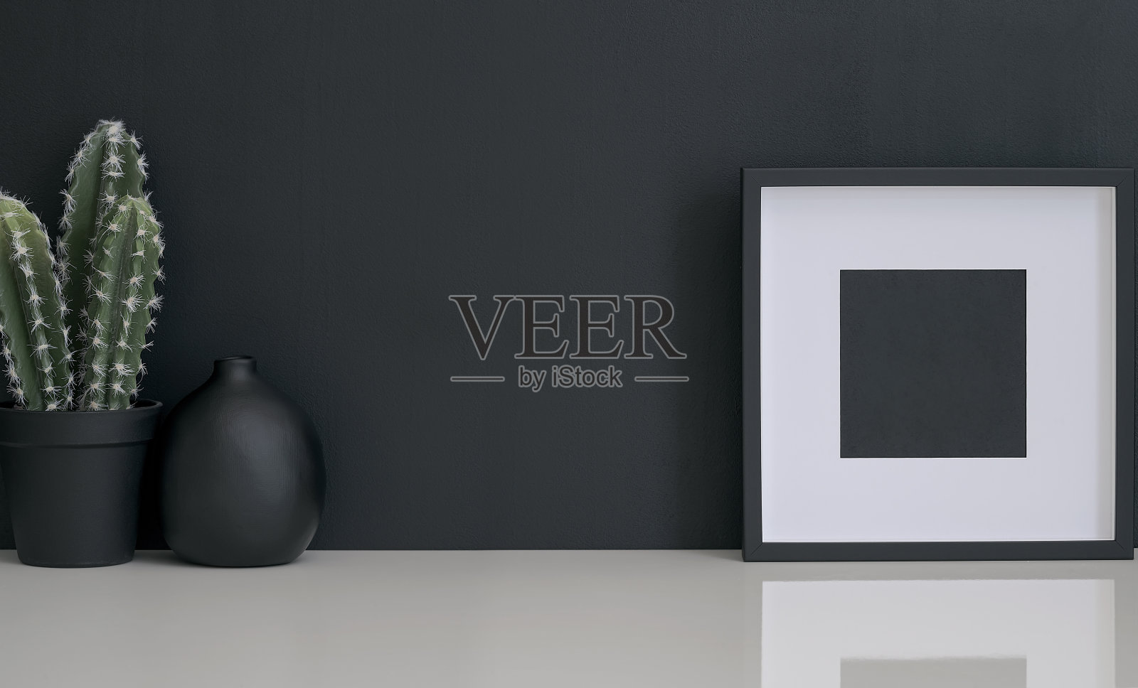 黑色的创意工作空间与黑色相框和绿色仙人掌在白色的桌子上。照片摄影图片