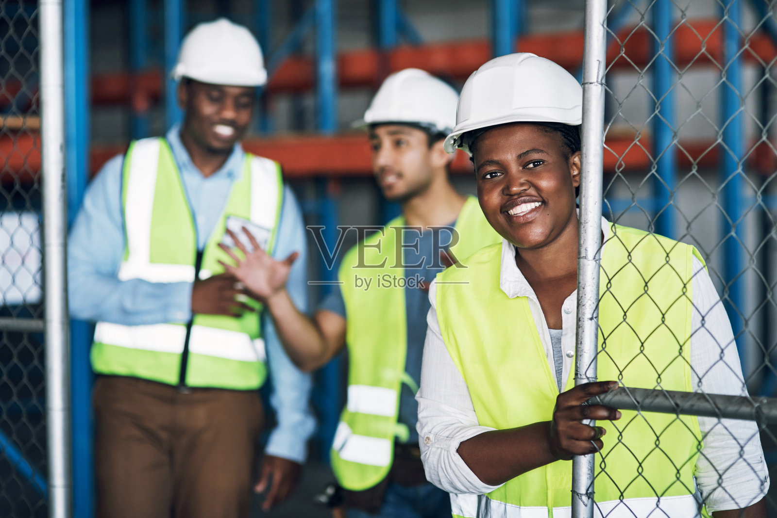 一个年轻的建筑工人正在打开通往建筑工地的大门照片摄影图片