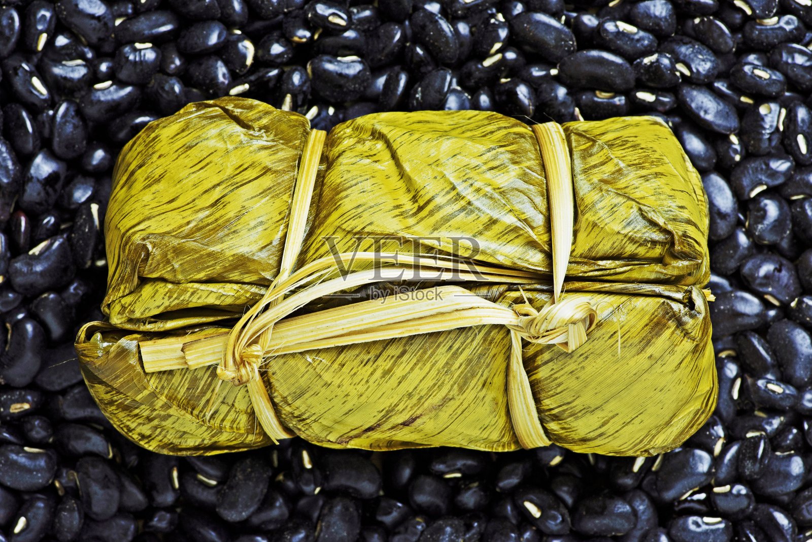 香蕉叶糯米饭-黑豆背景。照片摄影图片