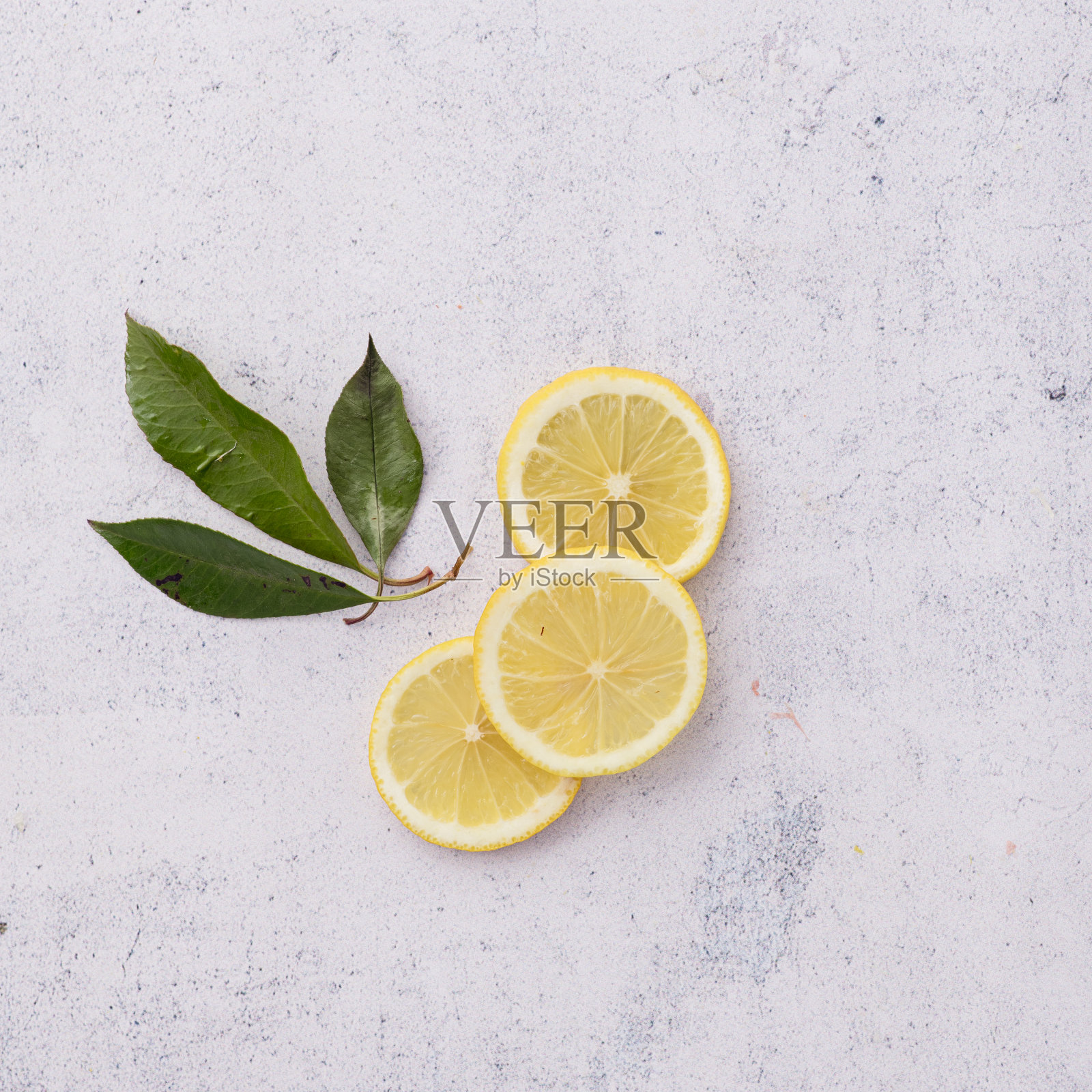 三片柠檬，叶子在白色的背景上。最小的静物画。前视图。照片摄影图片
