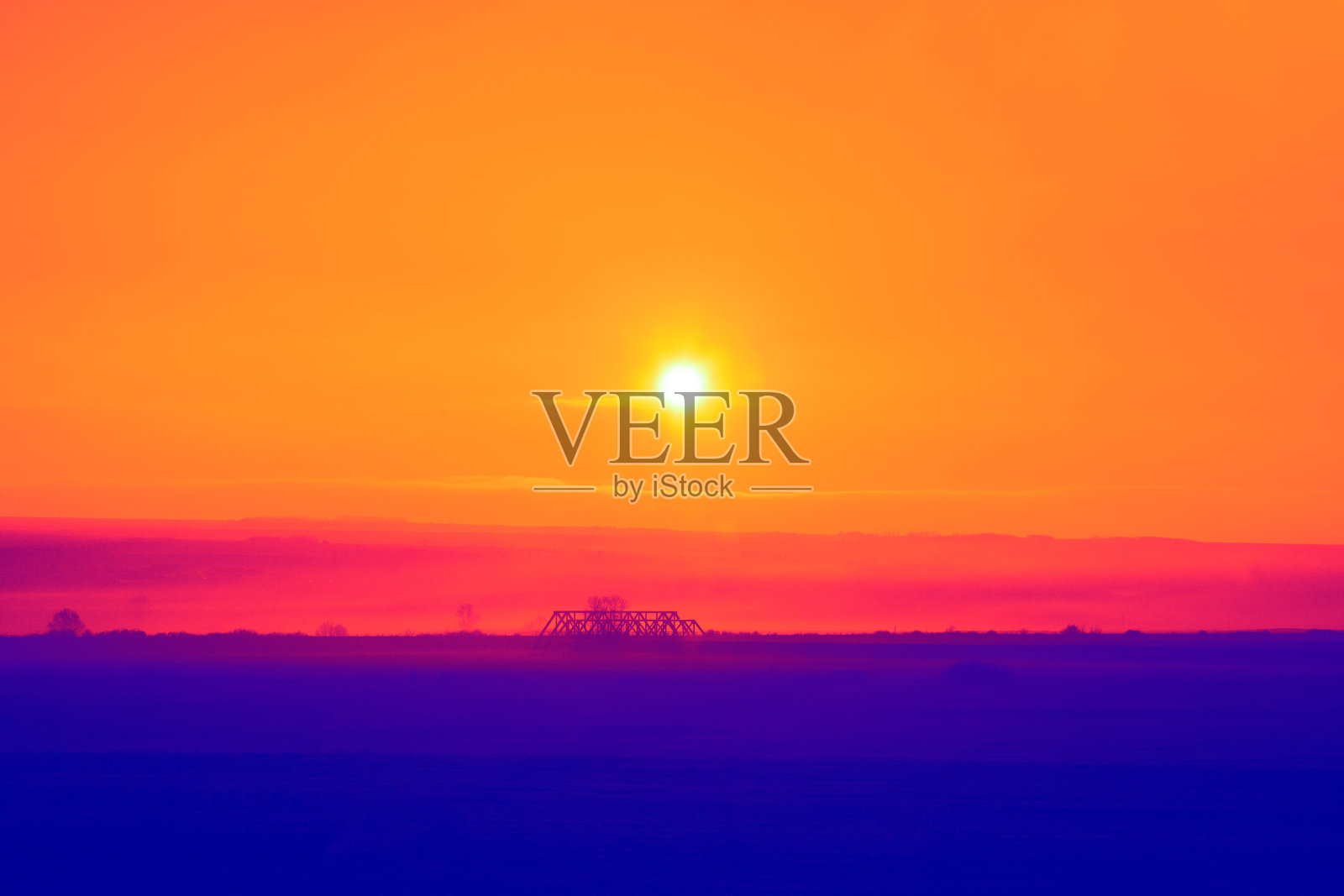 蓝色的土地，橙色的天空和夕阳照片摄影图片