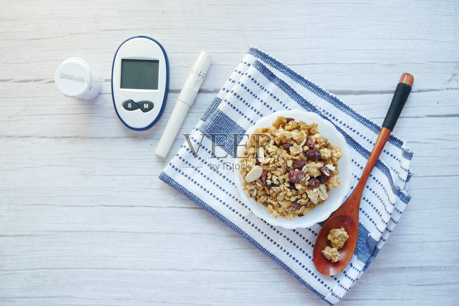 糖尿病测量工具和早餐麦片放在桌子上的碗里照片摄影图片