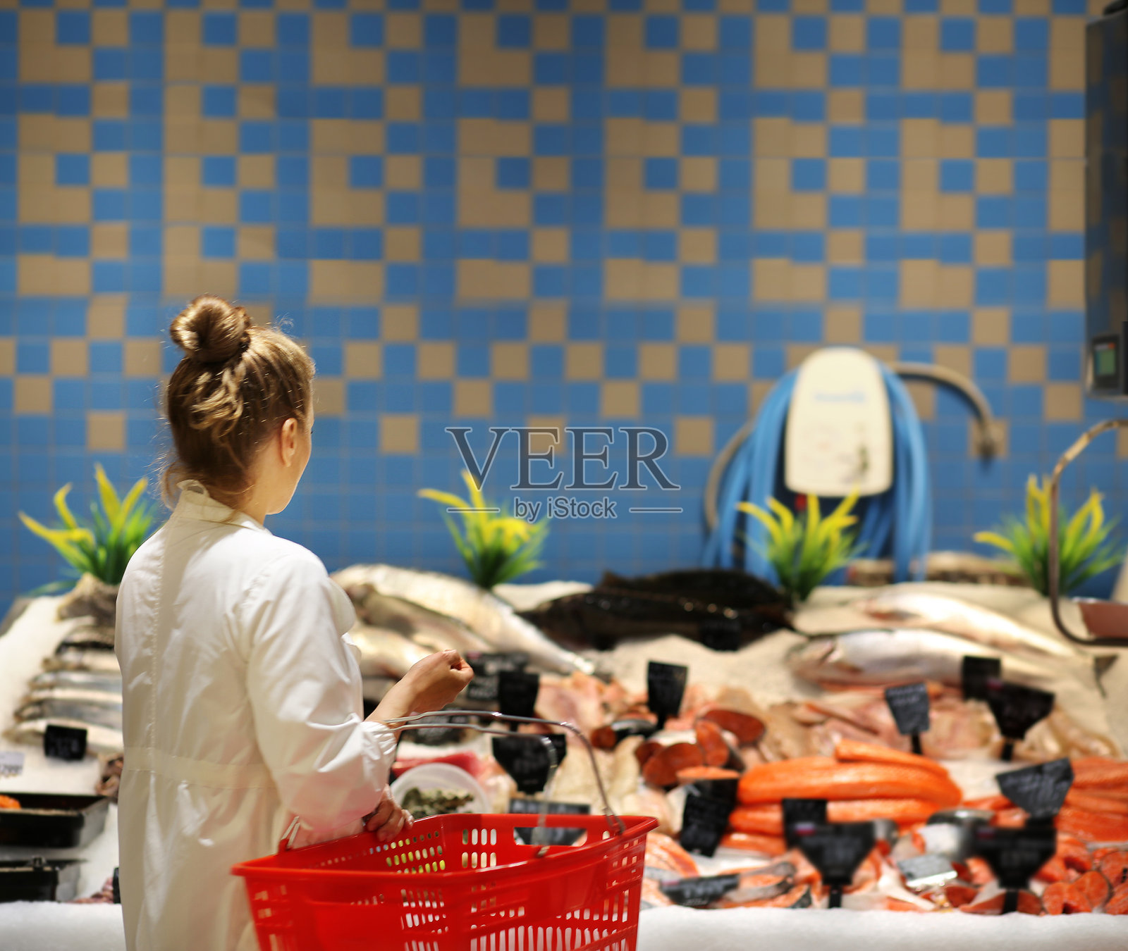 一个女人在超市里买新鲜的鱼和海鲜照片摄影图片