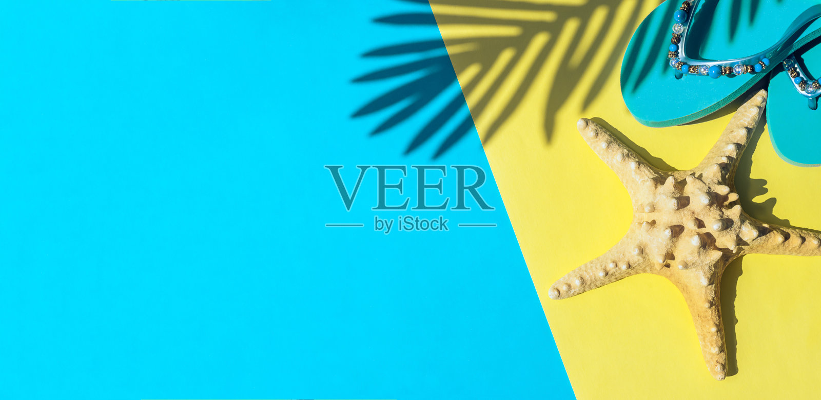 干海星，蓝色沙滩人字拖，黄色和蓝色背景上棕榈叶的影子。夏季和旅游概念。照片摄影图片