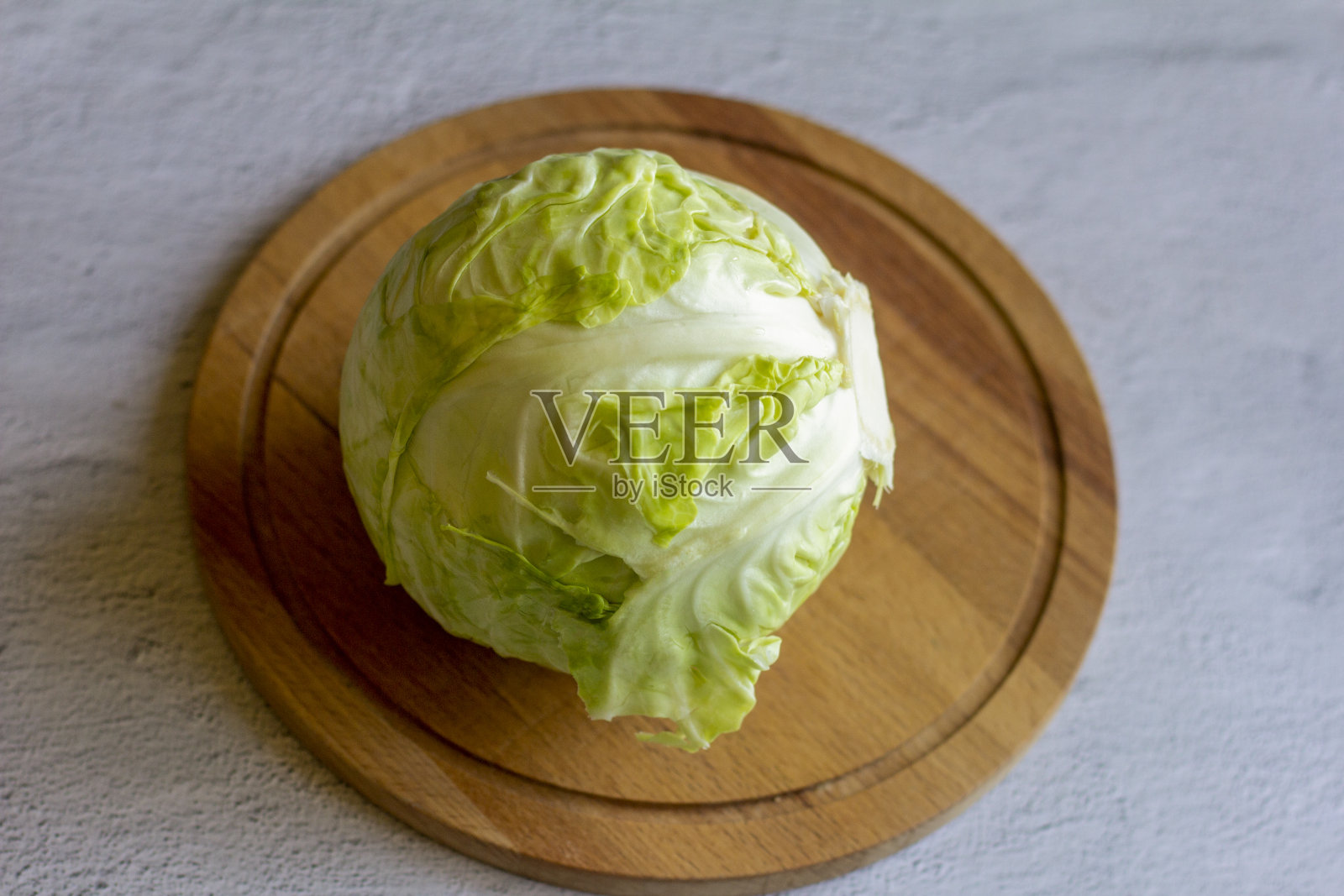 早期卷心菜，白色的卷心菜头在木制的背景上。照片摄影图片