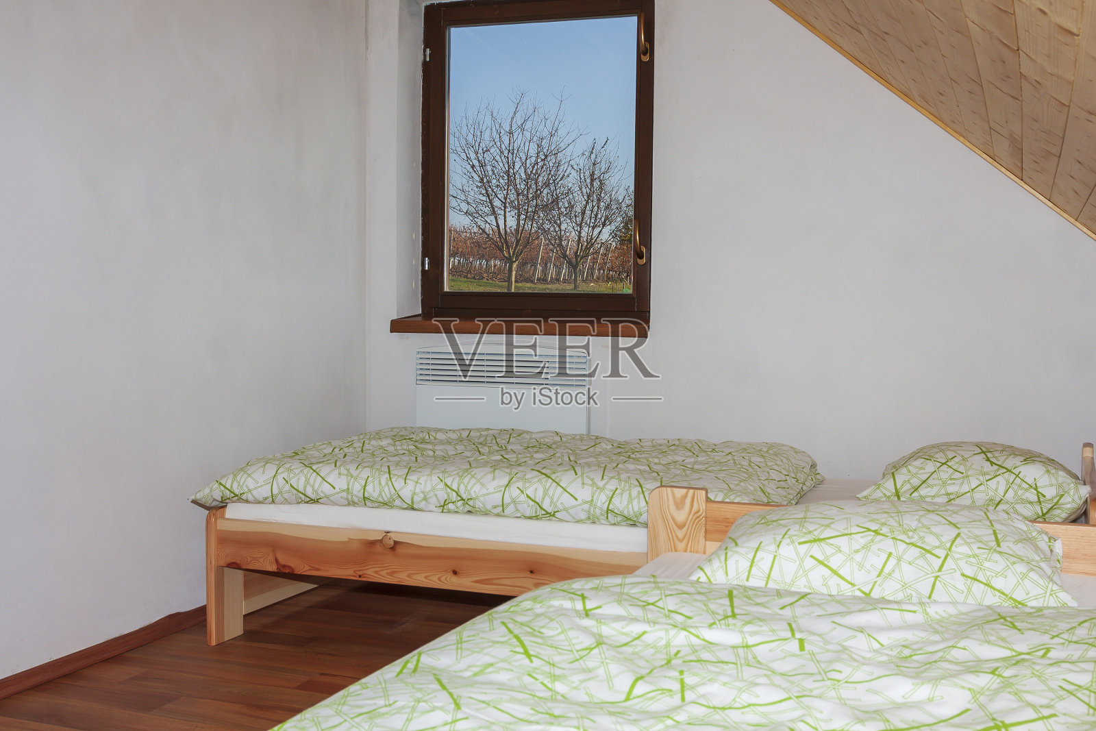 房间里有两张床，白色的墙壁和俯瞰葡萄园的窗户照片摄影图片