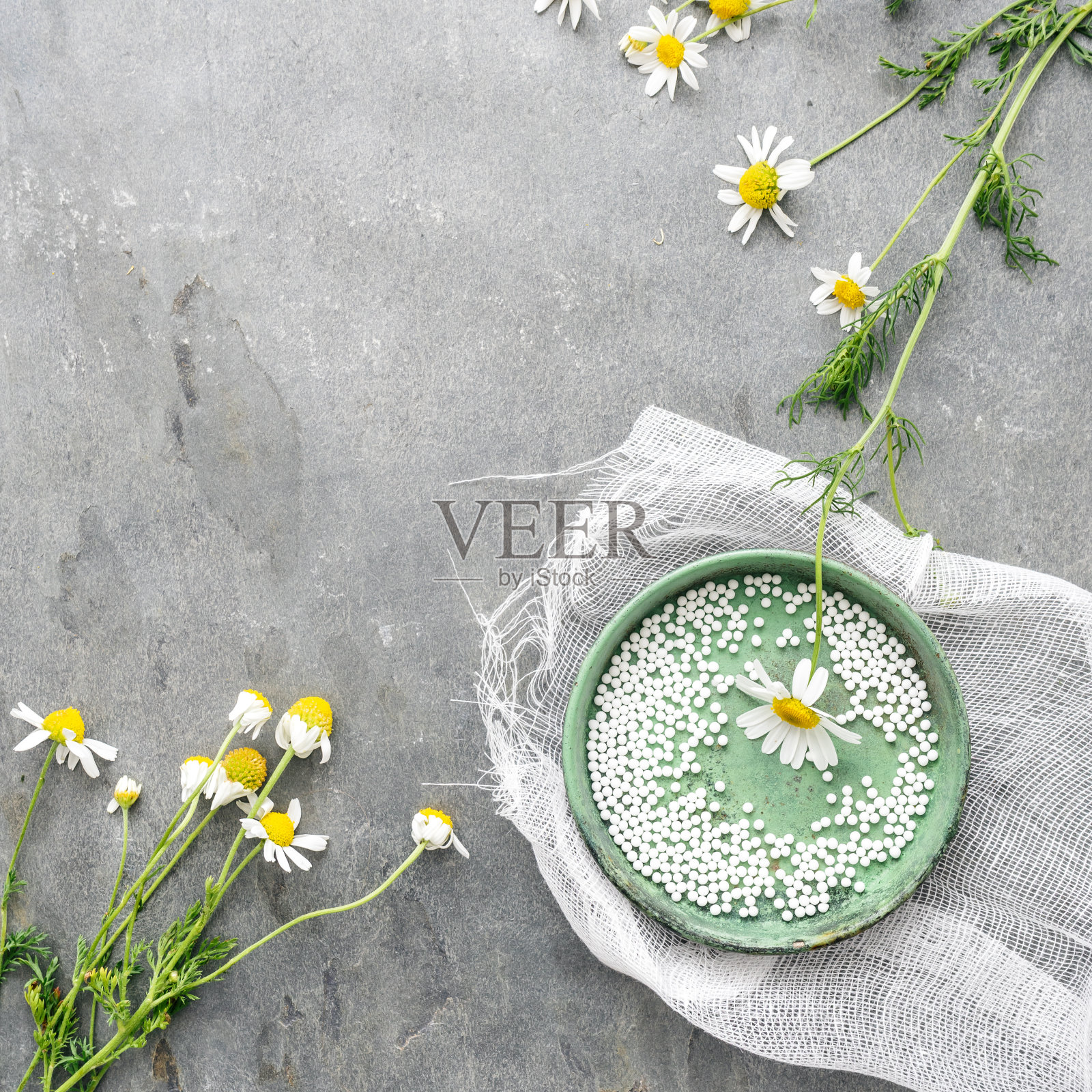 一张质朴的桌子上放着球和洋甘菊花。照片摄影图片