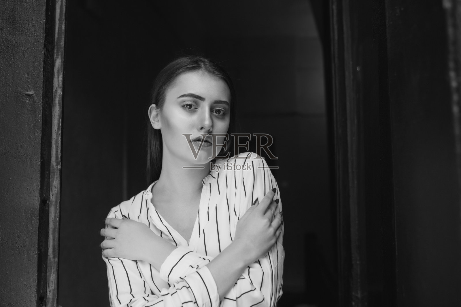 室内一个黑白相间的凄美优雅的年轻女子穿着条纹白衬衫照片摄影图片