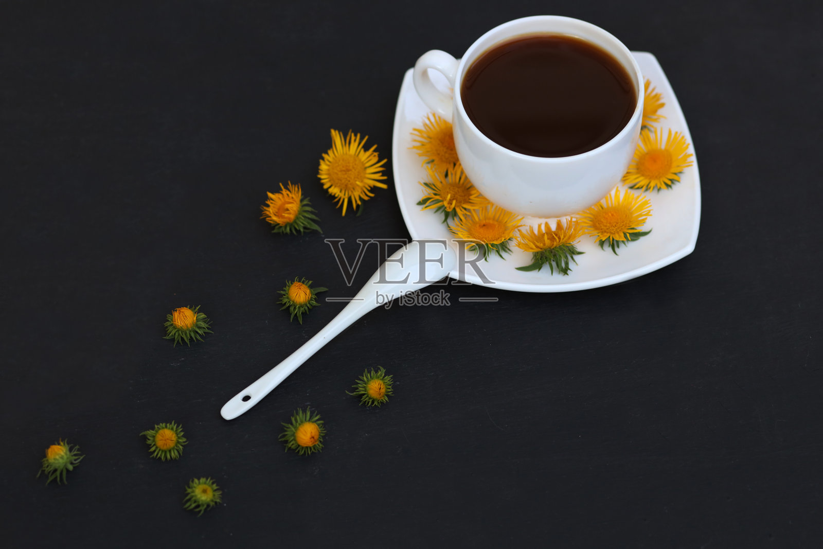 深色背景上的白咖啡。用黄花装饰。的音调。照片摄影图片