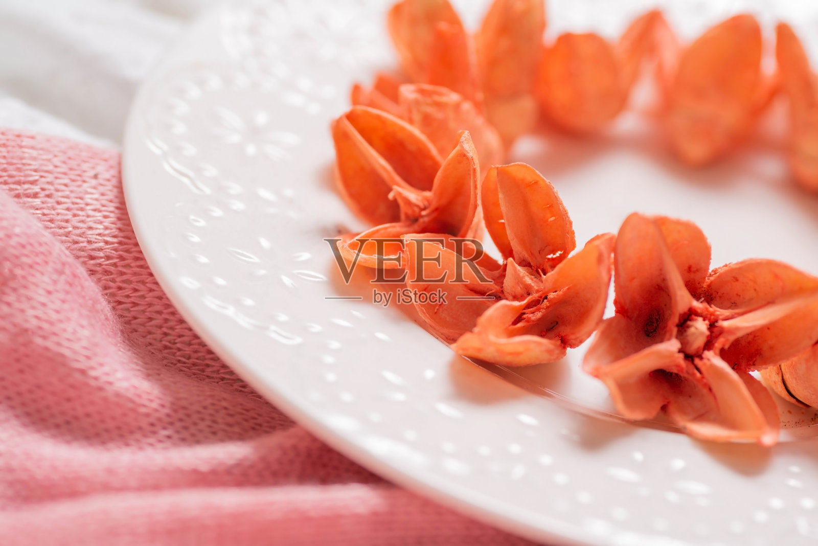 盘子的碎片，有橙色芳香花的干芽。照片摄影图片