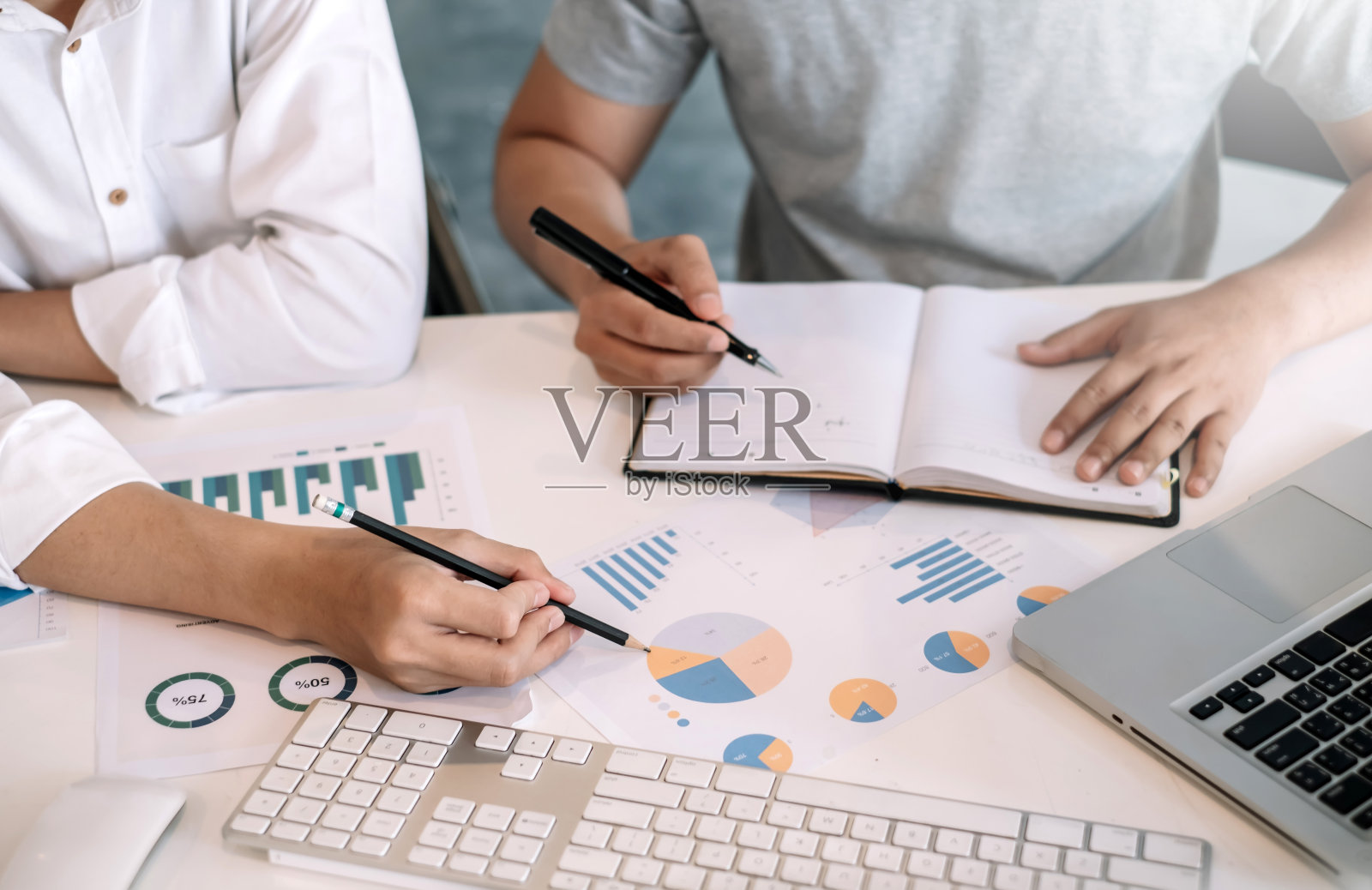 商务人士在办公室使用笔记本电脑分享工作想法和做笔记。照片摄影图片