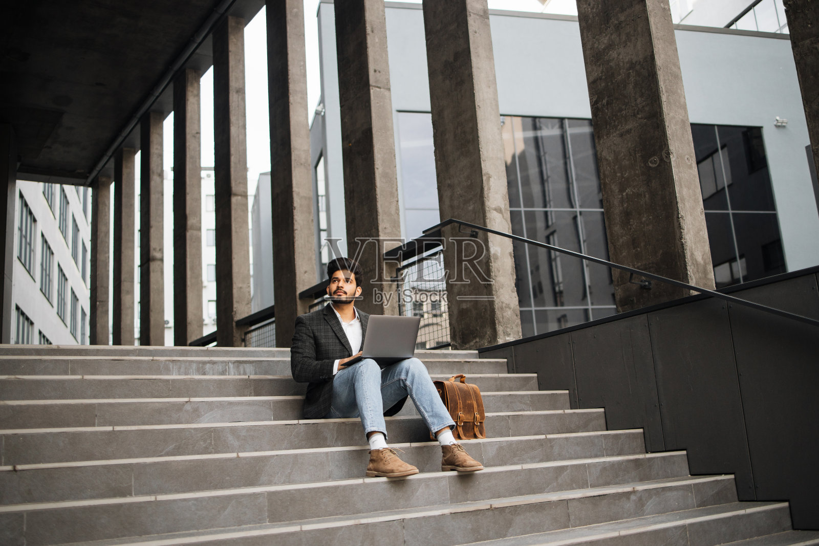 自信的印度人在户外无线笔记本电脑上工作照片摄影图片