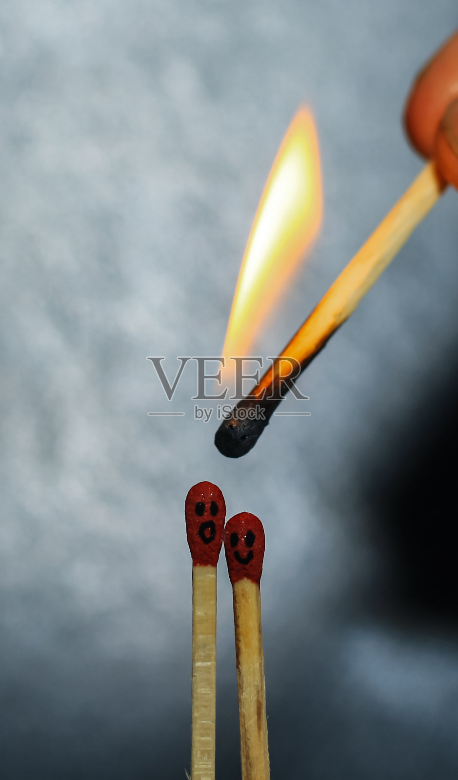 两根燃烧着的火柴坐在火柴盒上，在黑暗的复印空间里。两根火柴在火焰中作为一个隐喻在一起的友谊，爱情和浪漫的概念。火柴艺术摄影。照片摄影图片