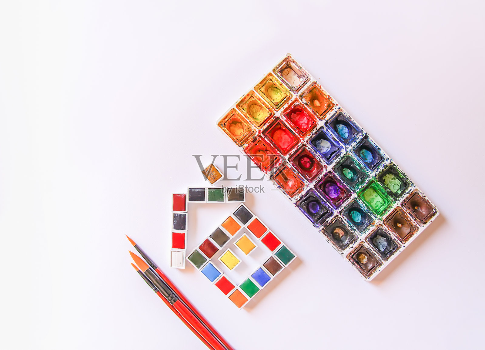 水彩颜料，刷子和纸在白色的背景。平躺，俯视图照片摄影图片