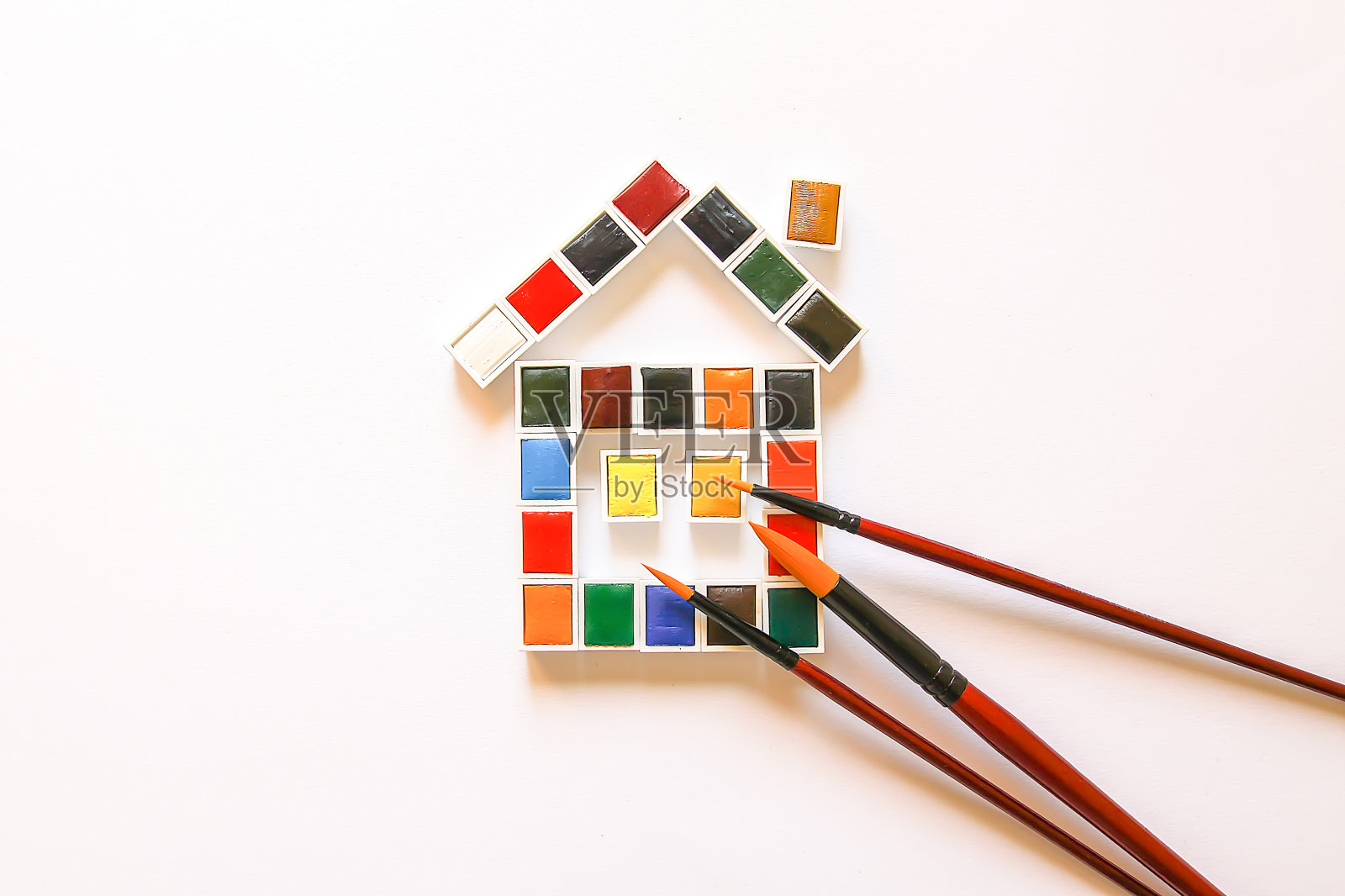 水彩颜料在房子的形状和油漆刷在白色的背景。绘画工具。平躺，俯视图照片摄影图片