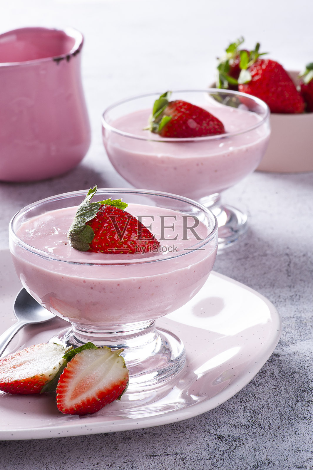 美味的草莓慕斯在玻璃碗与新鲜的草莓。照片摄影图片