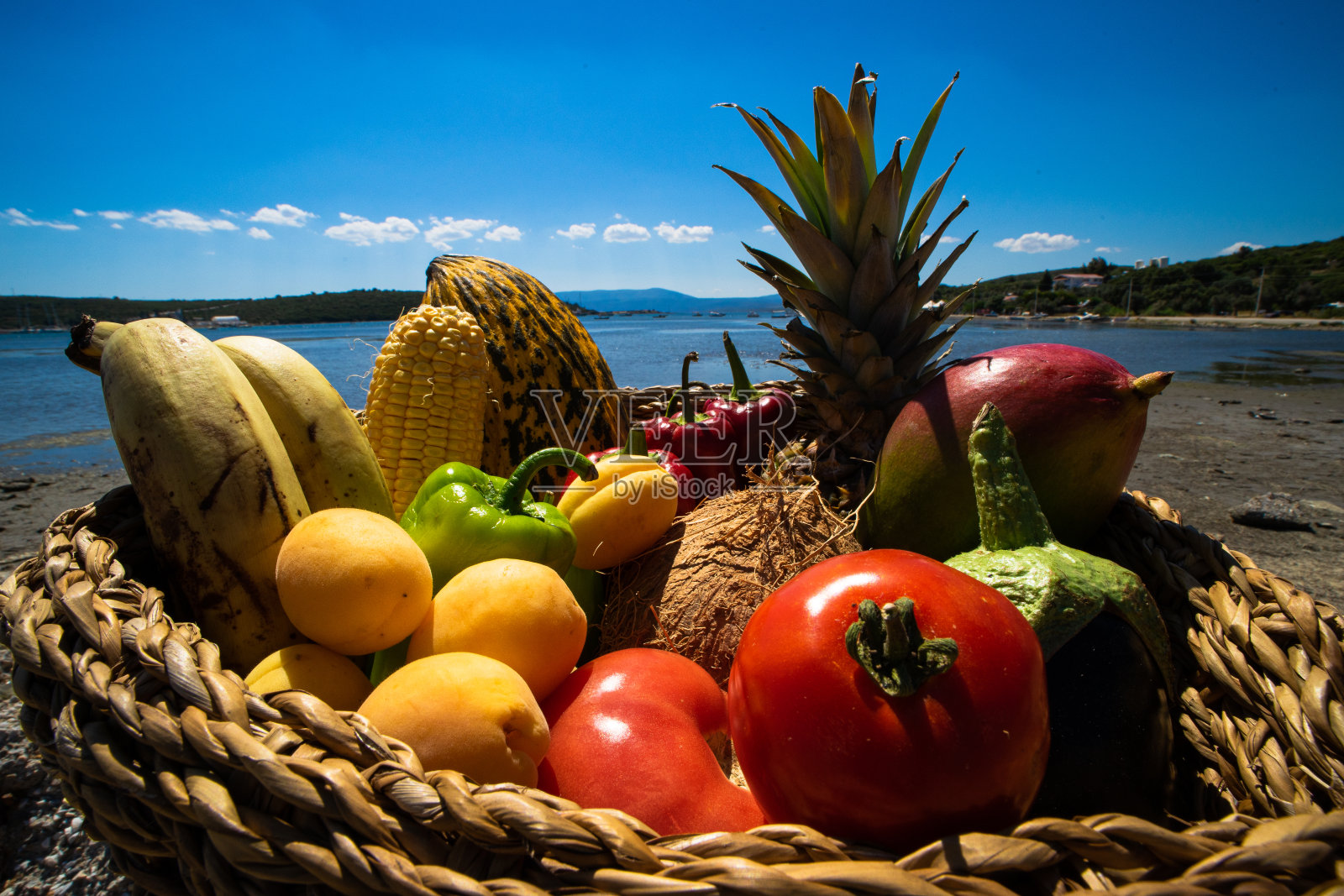 篮子里装满了丰富多彩的水果和蔬菜在广角海景背景照片摄影图片