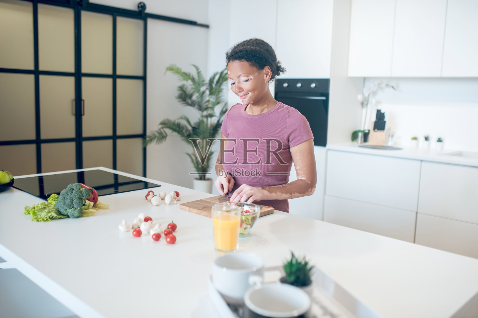 一个皮肤黝黑的女人正在厨房里切菜照片摄影图片