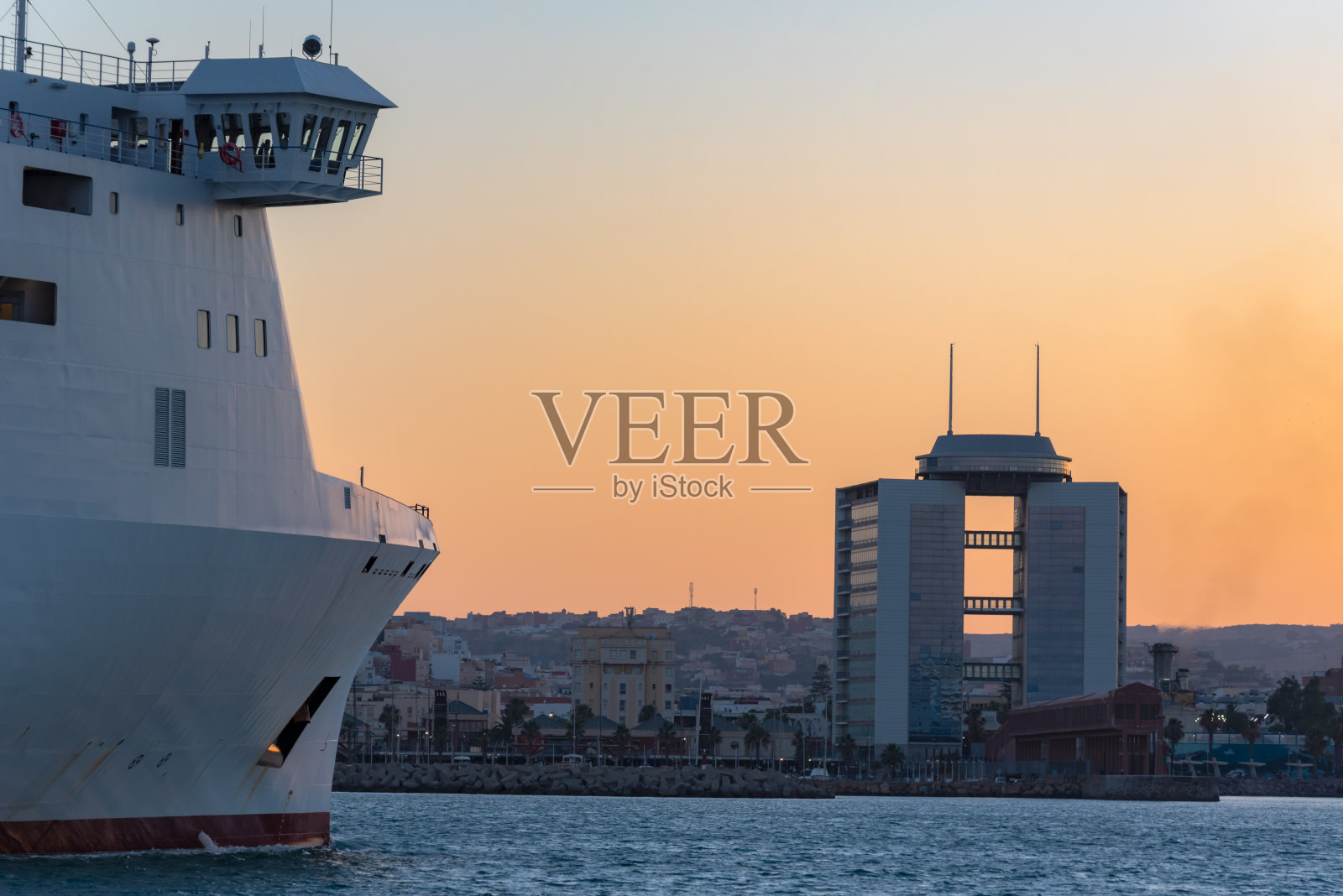 日落时分，客轮或渡轮进入梅利利亚港照片摄影图片