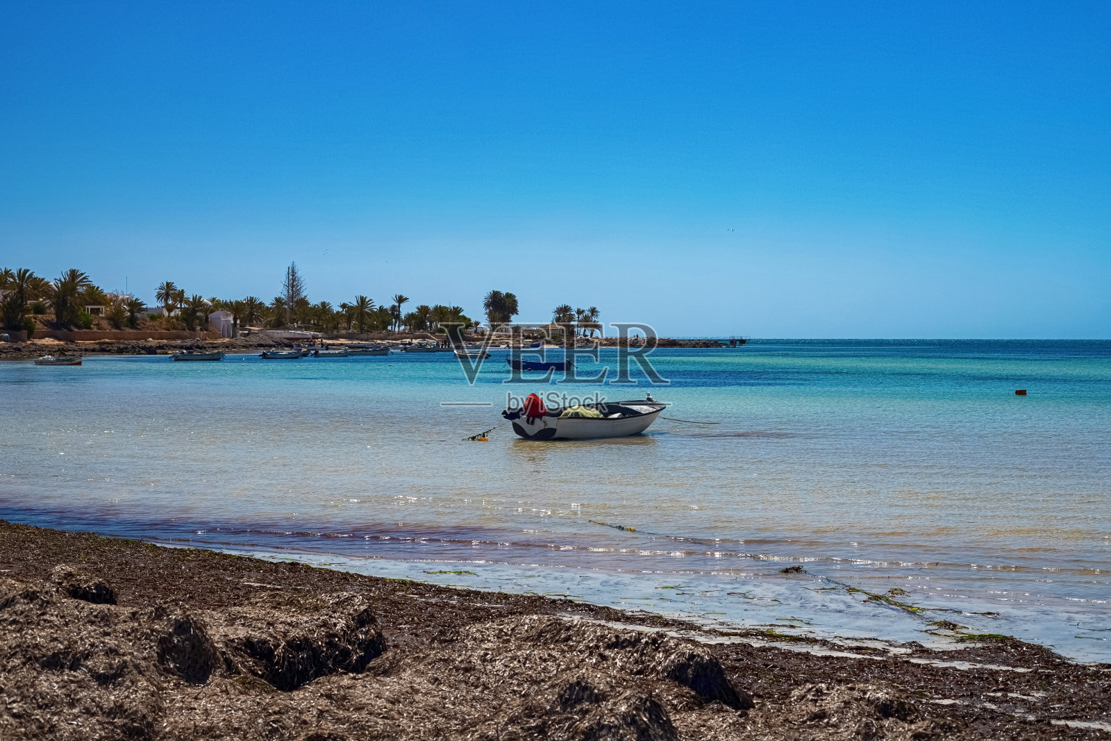 美丽的地中海海岸桦树水，白色沙滩和一艘渔船照片摄影图片