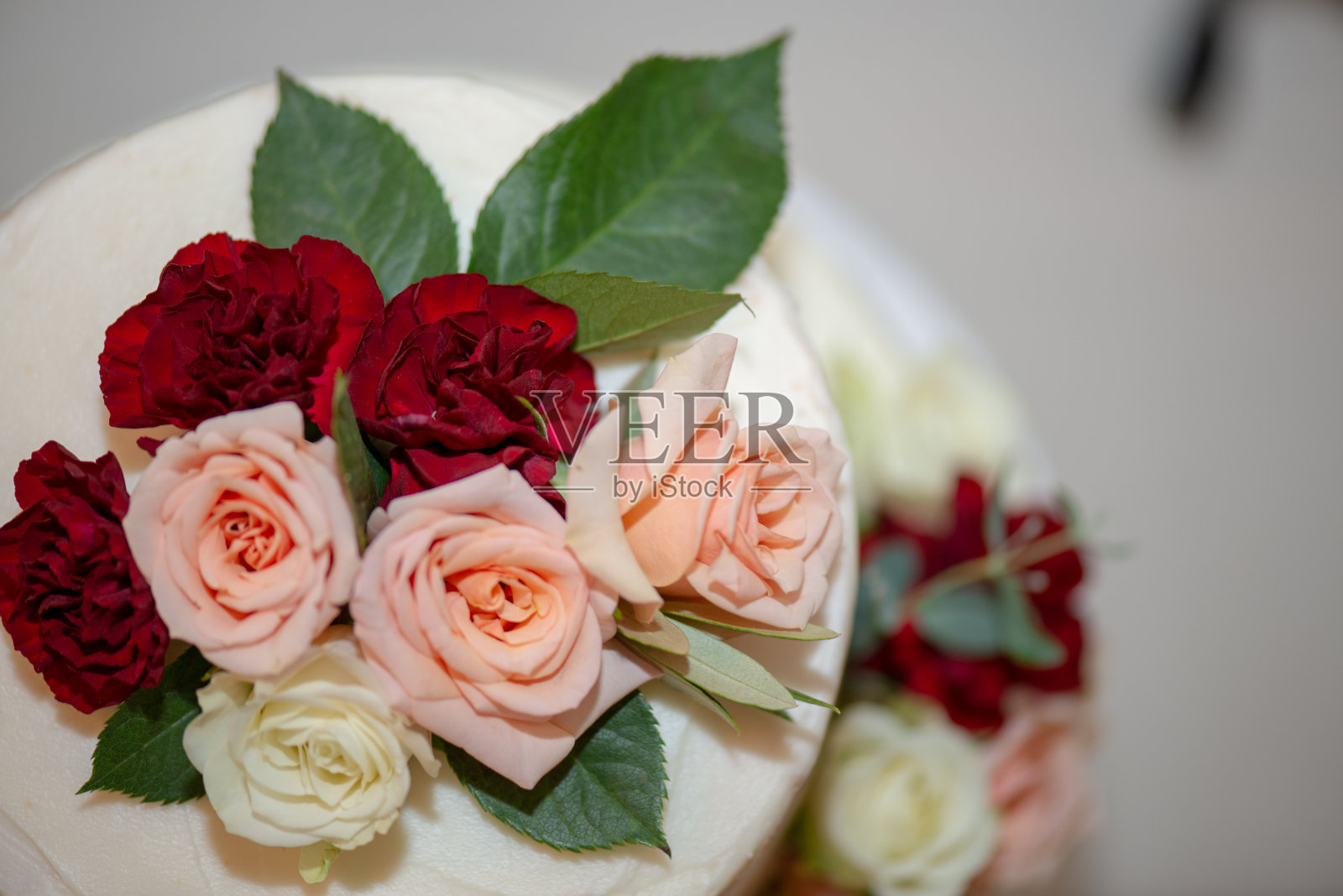 白色三层裸婚蛋糕，粉、红、白玫瑰照片摄影图片