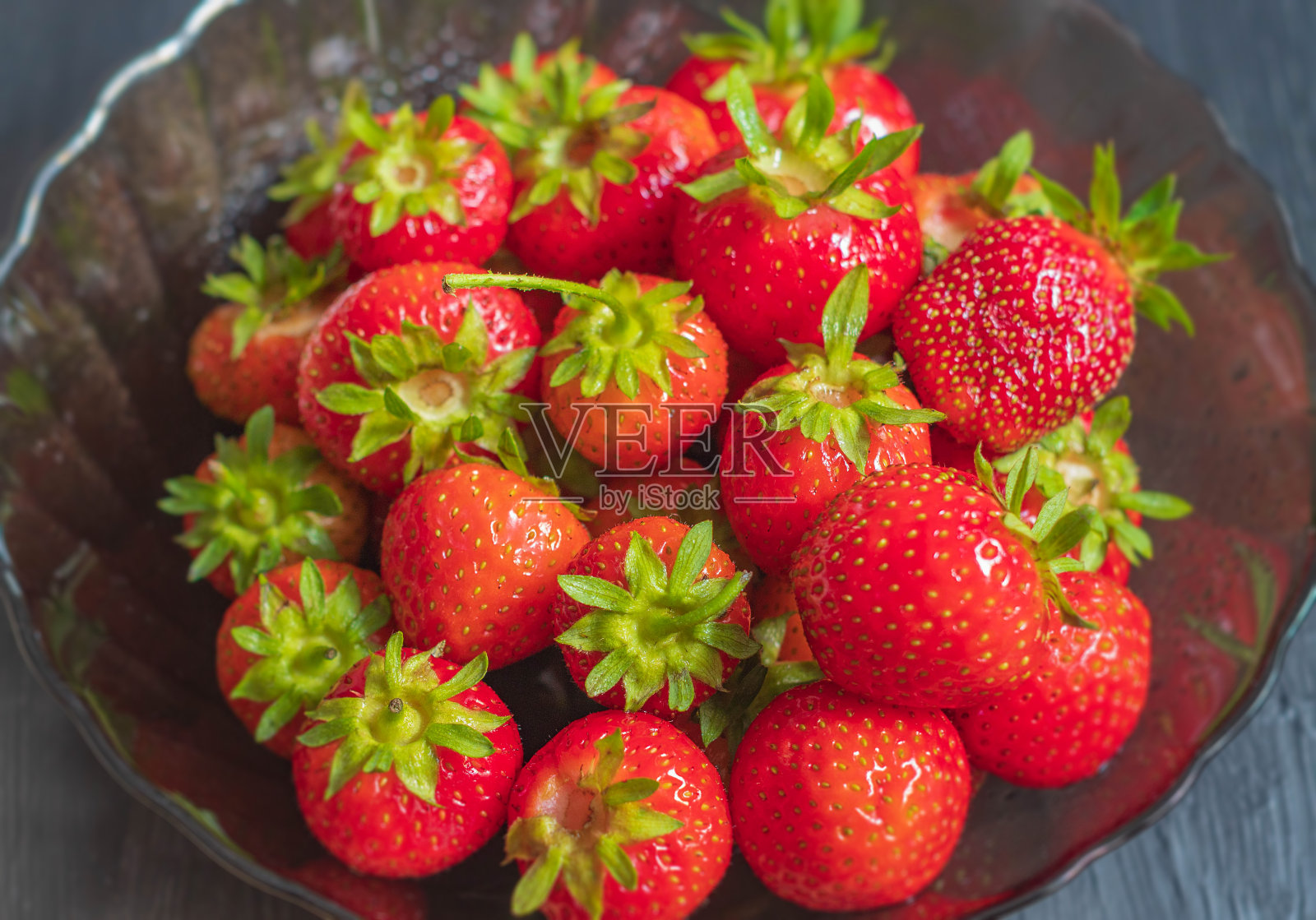 一小块熟透多汁的草莓放在盘子里照片摄影图片