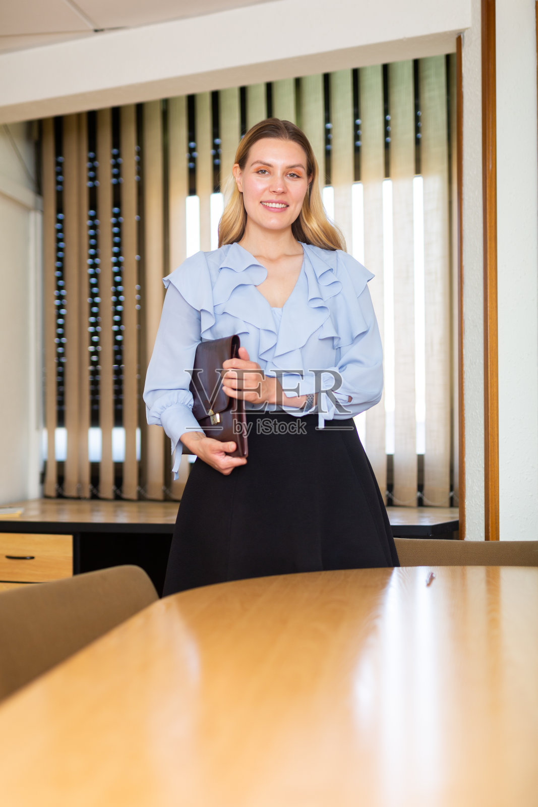 女商人拿着公文箱站在办公室里照片摄影图片