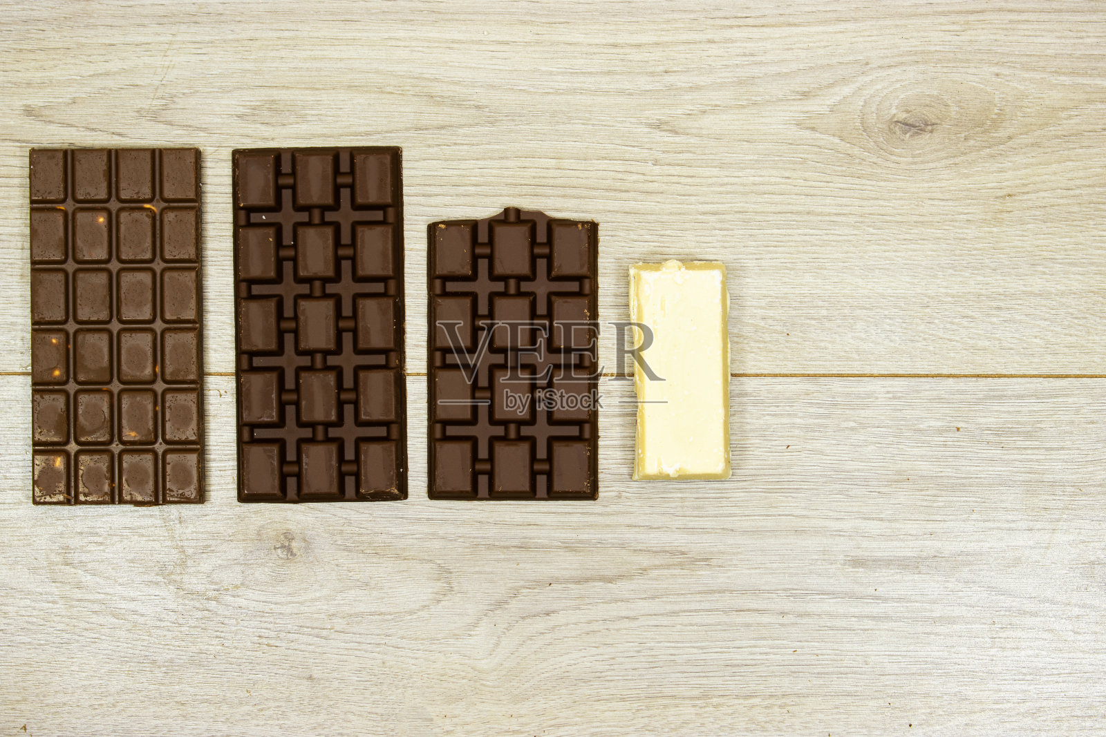 木桌上放着牛奶和黑、白巧克力照片摄影图片
