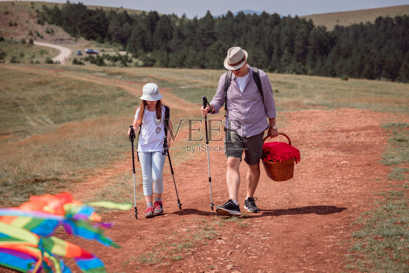 父亲和女儿用登山杖去野餐照片摄影图片