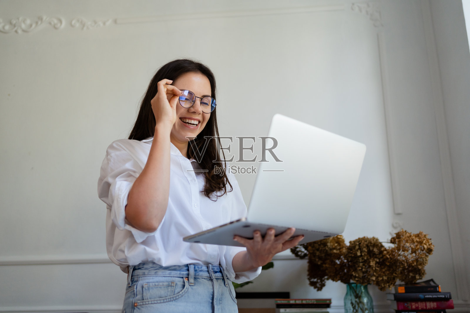 女商人坐在家里用笔记本电脑工作，通过家庭办公室管理她的业务照片摄影图片