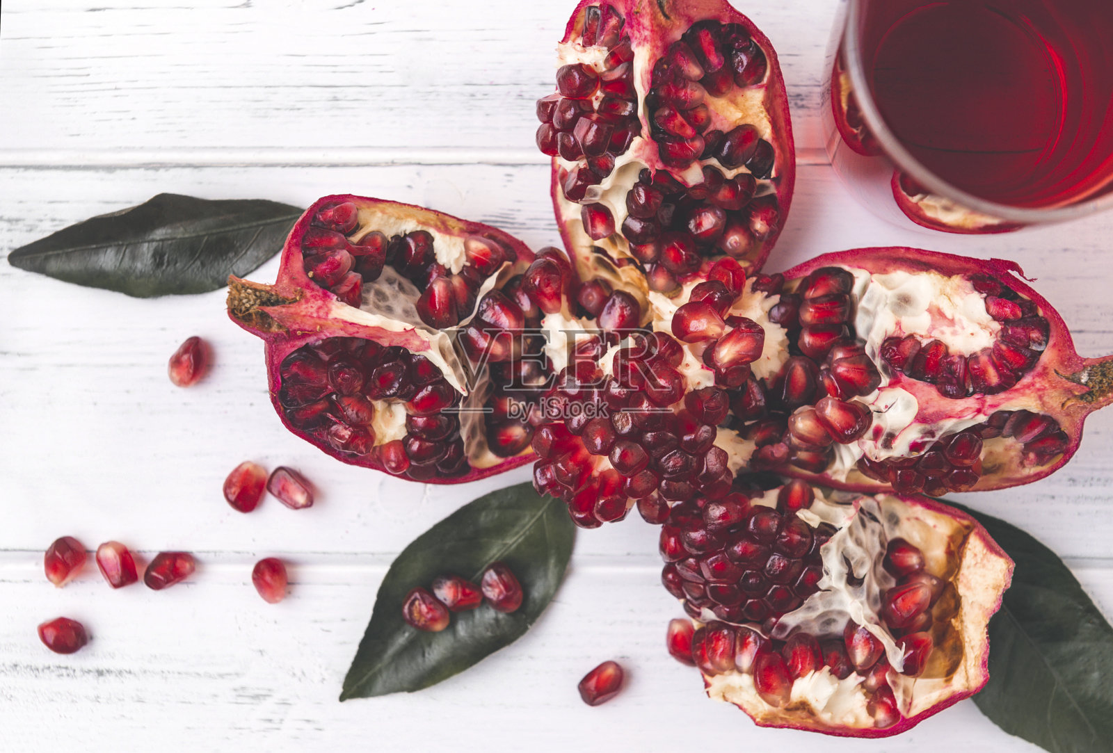 成熟的红石榴，一杯果汁上的白色木质背景俯视图照片摄影图片