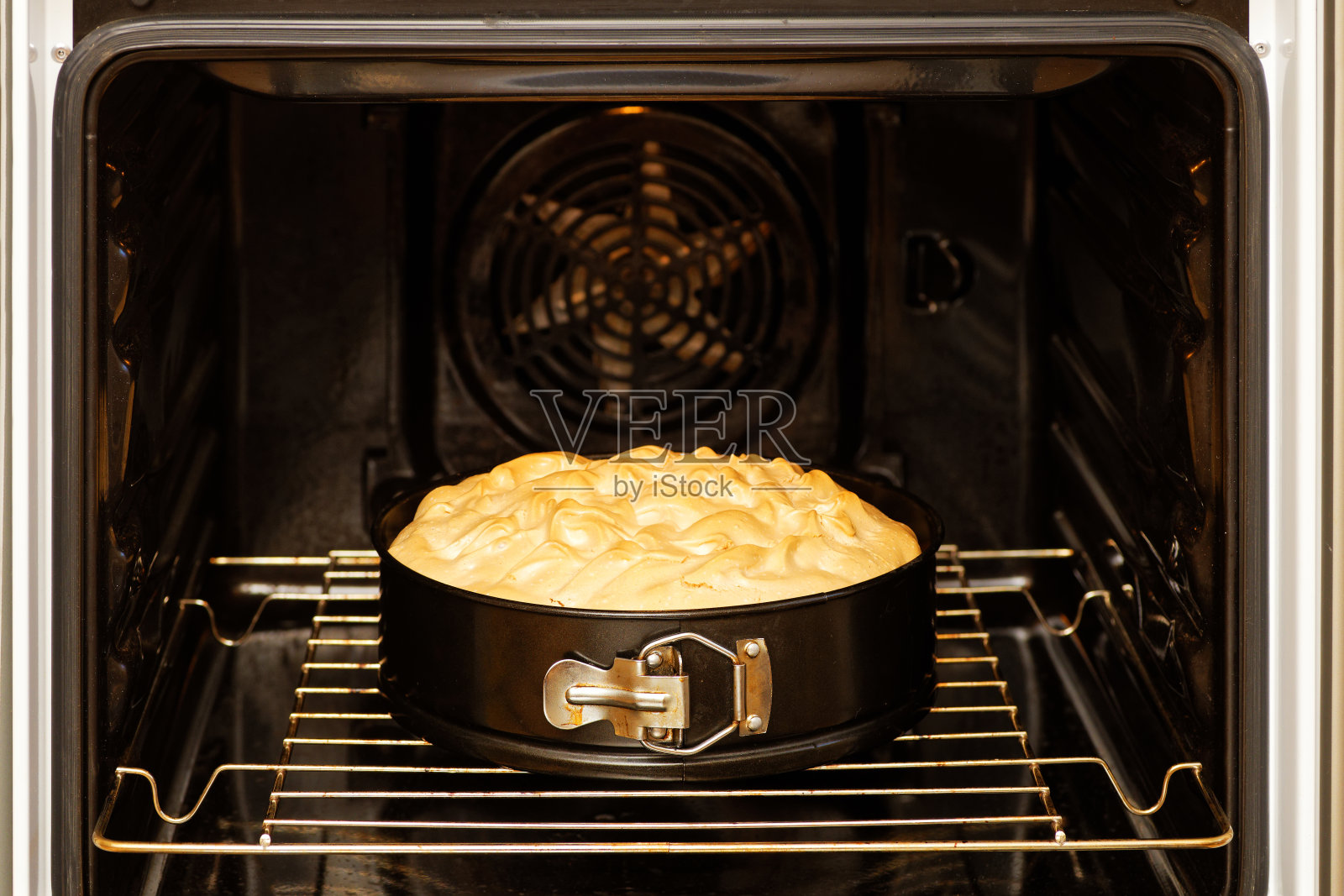 特写自制浆果派装饰蛋白霜是准备在家庭烤箱。照片摄影图片