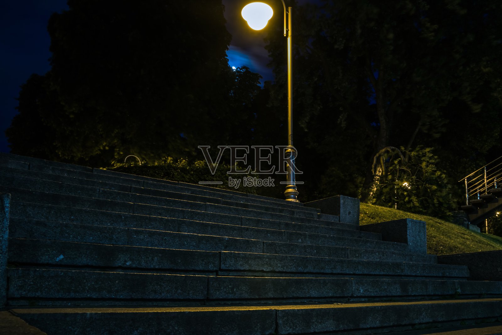 夜晚绿油油的公园里铺着瓷砖的楼梯，夏天还挂着灯笼。夏天晚上公园里的长椅。用灯笼照亮公园的道路。永荣公园。乌克兰照片摄影图片