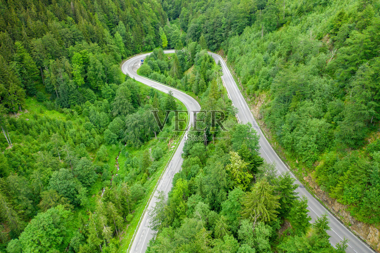 鸟瞰图的山路在森林与移动的汽车照片摄影图片