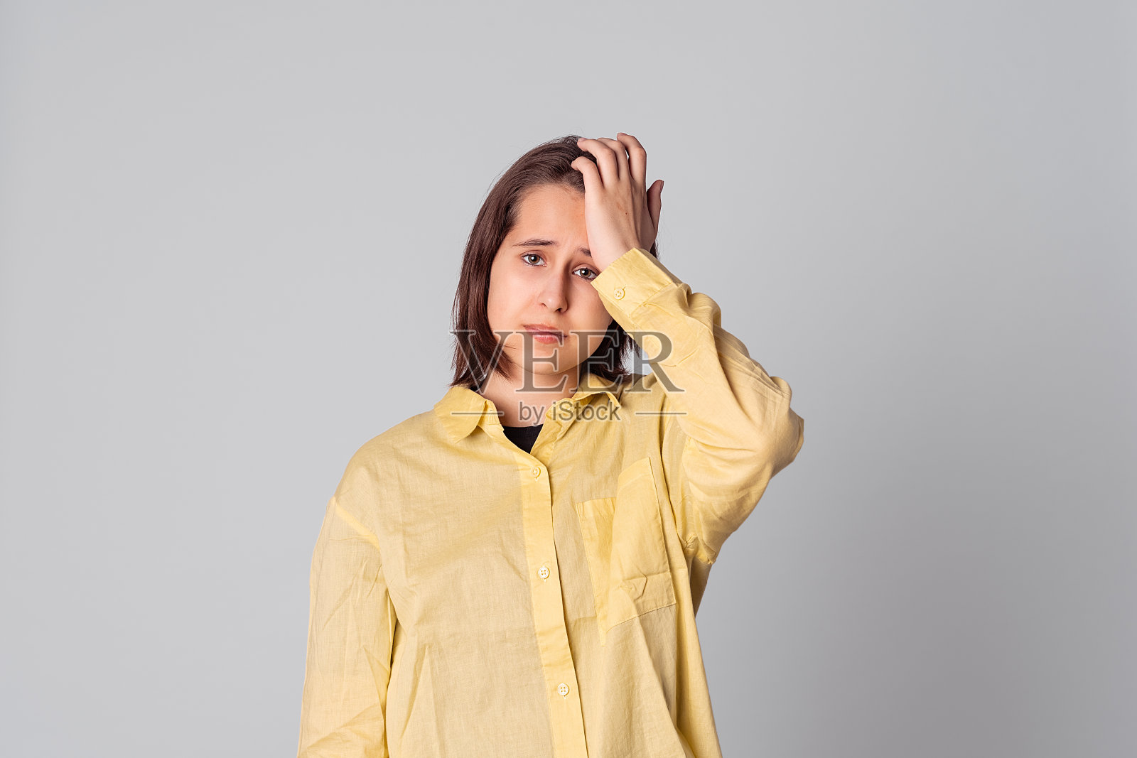 问题少女忘记或记得某件事，手放在额头上，捂着脸，撅着嘴照片摄影图片